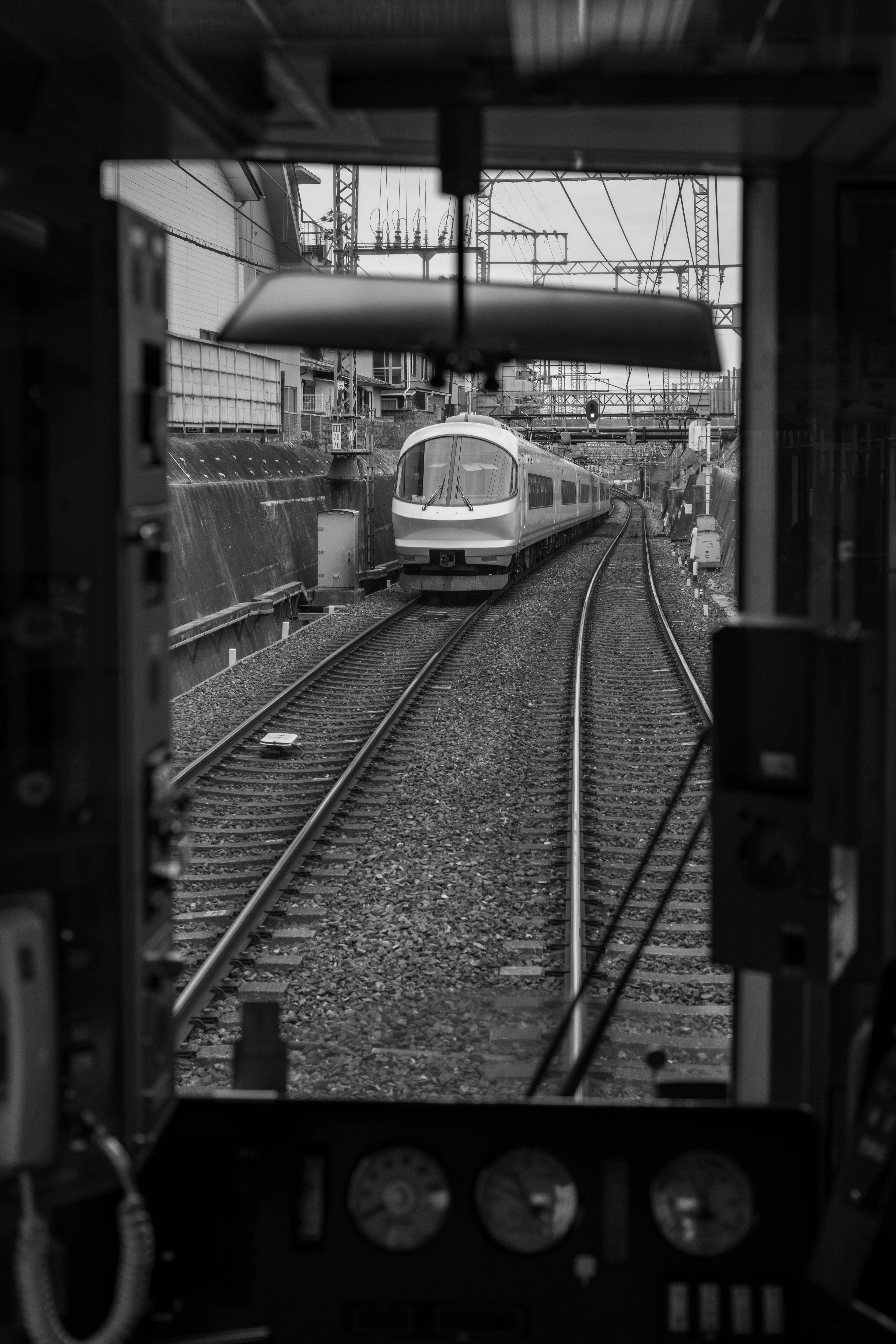 A train is seen passing by, through the train driver's window.