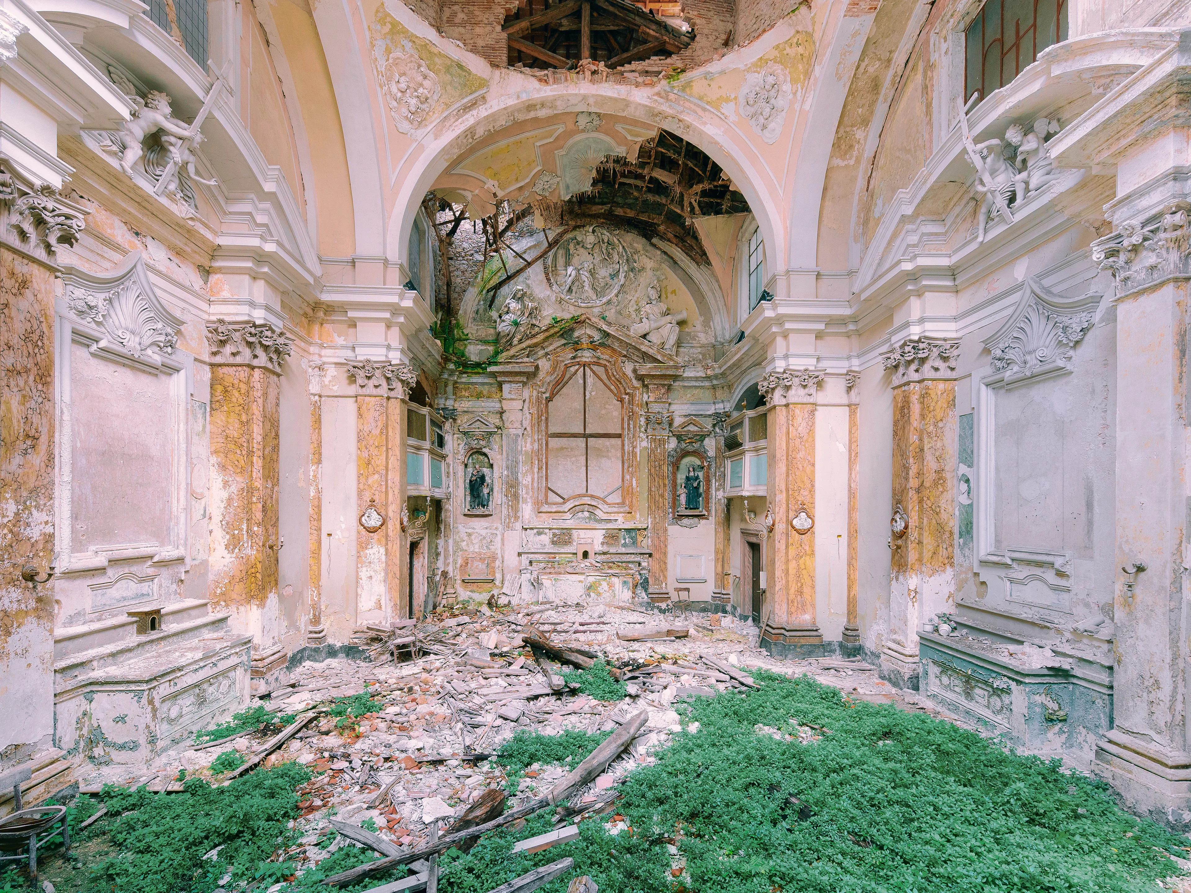 A Catholic church in a former hospital in Italy. Especially are elaborate stucco work and angels above the altar. Even the holy figures in the display cases are still in place despite the decay.
