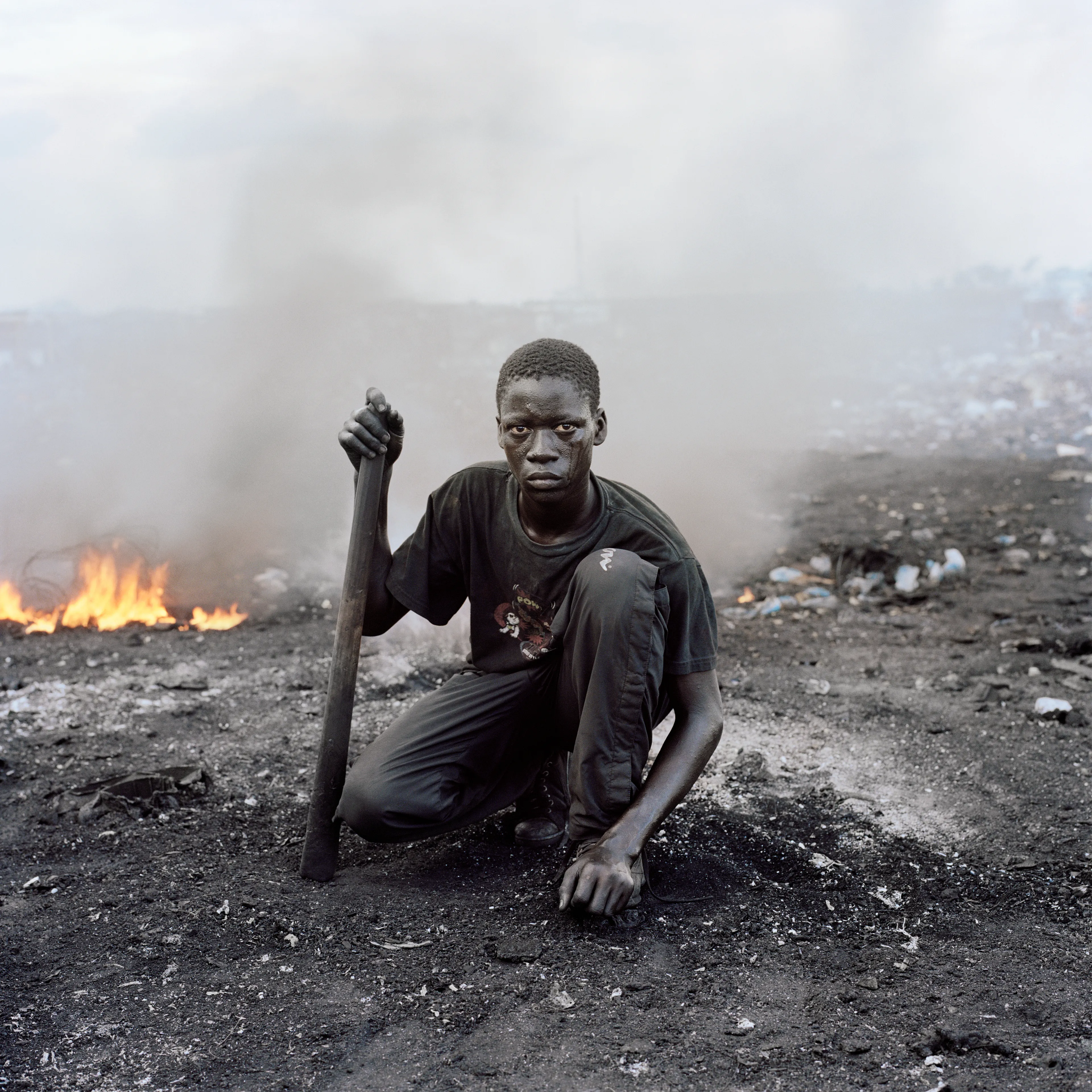 "This essay was photographed on a densely populated triangle of land in the Ghanaian capital of Accra. Bounded by the Abossey Okai Road and Odaw River, a polluted waterway that flows into the Korle Lagoon, Agbogbloshie is the second largest e-waste processing area in West Africa. It abuts Old Fadama, an impoverished settlement that offers northern migrants to the city the cheapest rents and a convenient base close to the central markets, a major employer. Home to an estimated 80 000 inhabitants, this mixed-used area on a former wetland consists not only of formal and informal residences for disenfranchised migrants to the city, but a commercial bus depot, and a vast and differentiated marketplace that includes specialised e-waste markets. An irregular activity until a few years ago, large volumes of end-of-life computers and television are now handled by Ghana’s port daily. Shipped under pretext of being reusable electronic goods, items that are not saleable end up at Agbogbloshie, nicknamed by locals as ‘Sodom and Gomorrah’.

It is here that circuits, transistors, capacitors and semiconductors are reduced to their base metals. There is, one has to admit, something beautifully alchemical about what’s happening there: these devices that are the pinnacle of cultural achievement get transformed back into their base elements. Of course, this is the sympathetic reading of an artist. The political ecologist Paul Robbins has described the dump as ‘a bizarre engine that maintains a self-replicating worldwide system of over-production’. I think it is fair to say that Agbogbloshie is a dark and dirty monument to the digital age, to our faith in technology and its built-in obsolescence. This idea of surplus and waste, which is key to our digital experience, is not one that many people seem comfortable addressing. Being in an environment like this, where geopolitical imbalances are being exploited to effectively dump waste on poor countries, it is hard not to take a political position. And so I have let my photographs be used by advocacy groups.

I first encountered the dump in a photograph published by National Geographic. This is a recurrent theme in my photography, how photographs prompt me to make my own photographs. The work was produced during two trips of two weeks each. I tend to photograph over two-week stretches. I find this is a period in which I can keep my eye fresh. After that you become too accustomed to a place. It was something I realised in Rwanda, how quickly one becomes desensitised and acclimatised to completely unacceptable situations, how the mind is capable of this". -  Pieter Hugo

Edition: 1 of 1