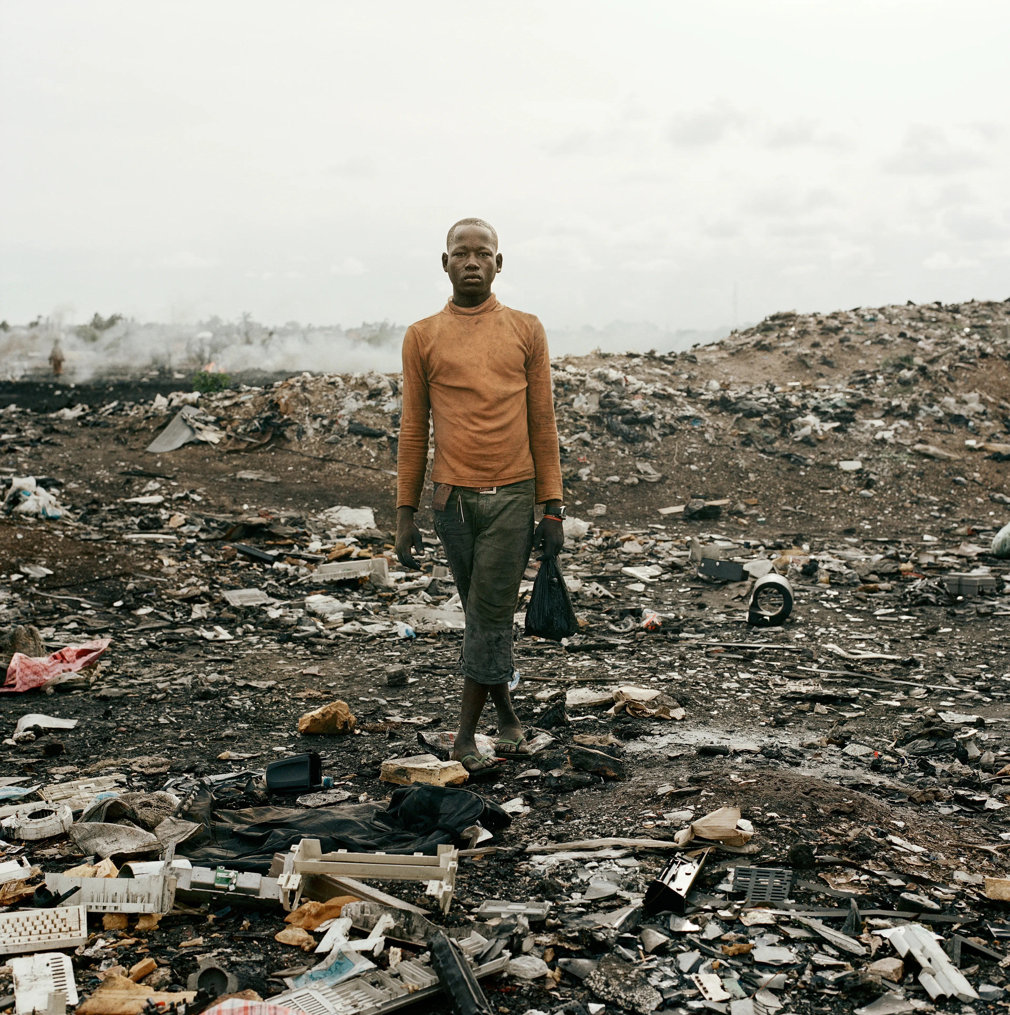 "This essay was photographed on a densely populated triangle of land in the Ghanaian capital of Accra. Bounded by the Abossey Okai Road and Odaw River, a polluted waterway that flows into the Korle Lagoon, Agbogbloshie is the second largest e-waste processing area in West Africa. It abuts Old Fadama, an impoverished settlement that offers northern migrants to the city the cheapest rents and a convenient base close to the central markets, a major employer. Home to an estimated 80 000 inhabitants, this mixed-used area on a former wetland consists not only of formal and informal residences for disenfranchised migrants to the city, but a commercial bus depot, and a vast and differentiated marketplace that includes specialised e-waste markets. An irregular activity until a few years ago, large volumes of end-of-life computers and television are now handled by Ghana’s port daily. Shipped under pretext of being reusable electronic goods, items that are not saleable end up at Agbogbloshie, nicknamed by locals as ‘Sodom and Gomorrah’.

It is here that circuits, transistors, capacitors and semiconductors are reduced to their base metals. There is, one has to admit, something beautifully alchemical about what’s happening there: these devices that are the pinnacle of cultural achievement get transformed back into their base elements. Of course, this is the sympathetic reading of an artist. The political ecologist Paul Robbins has described the dump as ‘a bizarre engine that maintains a self-replicating worldwide system of over-production’. I think it is fair to say that Agbogbloshie is a dark and dirty monument to the digital age, to our faith in technology and its built-in obsolescence. This idea of surplus and waste, which is key to our digital experience, is not one that many people seem comfortable addressing. Being in an environment like this, where geopolitical imbalances are being exploited to effectively dump waste on poor countries, it is hard not to take a political position. And so I have let my photographs be used by advocacy groups.

I first encountered the dump in a photograph published by National Geographic. This is a recurrent theme in my photography, how photographs prompt me to make my own photographs. The work was produced during two trips of two weeks each. I tend to photograph over two-week stretches. I find this is a period in which I can keep my eye fresh. After that you become too accustomed to a place. It was something I realised in Rwanda, how quickly one becomes desensitised and acclimatised to completely unacceptable situations, how the mind is capable of this". -  Pieter Hugo

Edition: 1 of 1