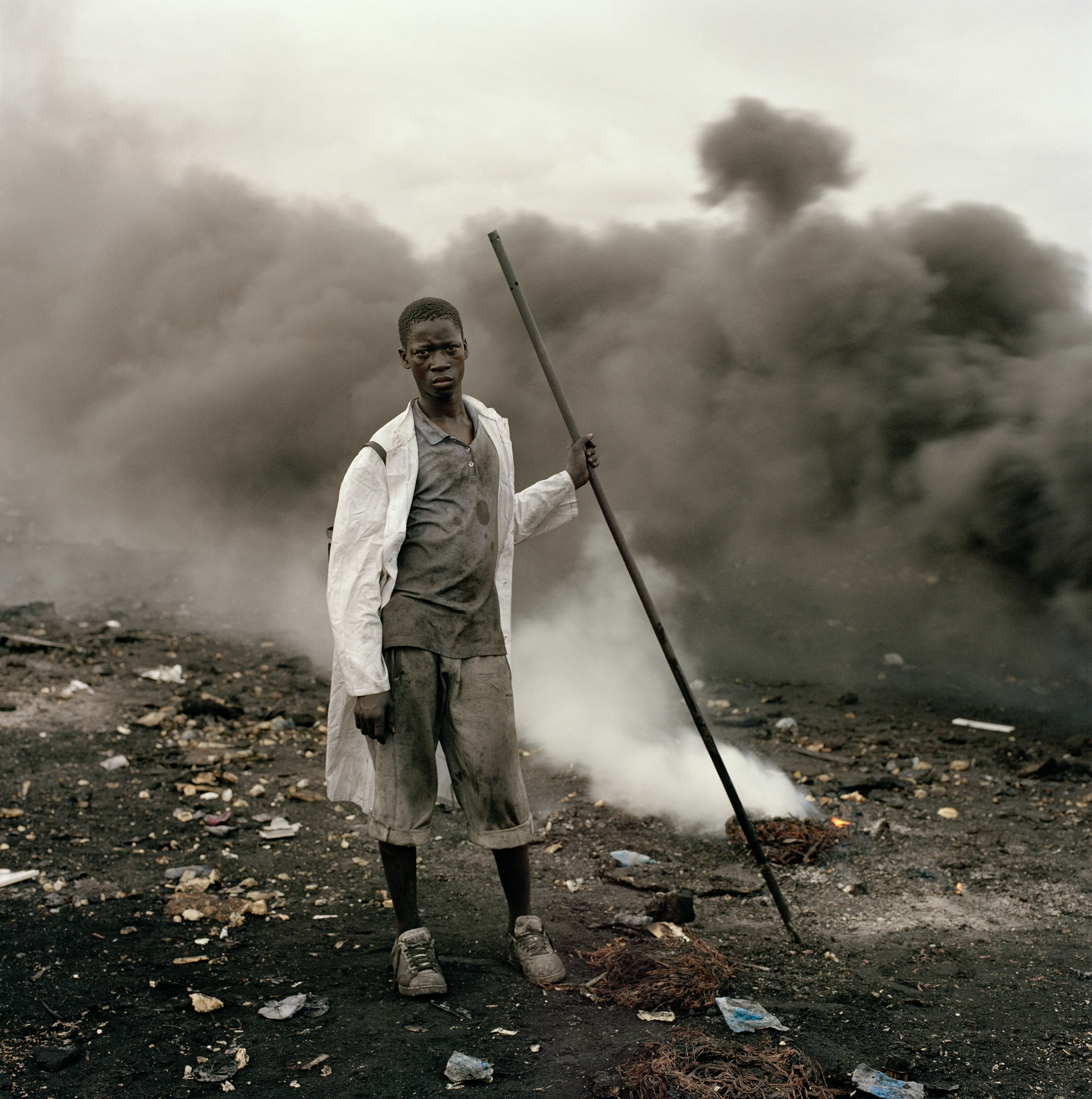 "This essay was photographed on a densely populated triangle of land in the Ghanaian capital of Accra. Bounded by the Abossey Okai Road and Odaw River, a polluted waterway that flows into the Korle Lagoon, Agbogbloshie is the second largest e-waste processing area in West Africa. It abuts Old Fadama, an impoverished settlement that offers northern migrants to the city the cheapest rents and a convenient base close to the central markets, a major employer. Home to an estimated 80 000 inhabitants, this mixed-used area on a former wetland consists not only of formal and informal residences for disenfranchised migrants to the city, but a commercial bus depot, and a vast and differentiated marketplace that includes specialised e-waste markets. An irregular activity until a few years ago, large volumes of end-of-life computers and television are now handled by Ghana’s port daily. Shipped under pretext of being reusable electronic goods, items that are not saleable end up at Agbogbloshie, nicknamed by locals as ‘Sodom and Gomorrah’.

It is here that circuits, transistors, capacitors and semiconductors are reduced to their base metals. There is, one has to admit, something beautifully alchemical about what’s happening there: these devices that are the pinnacle of cultural achievement get transformed back into their base elements. Of course, this is the sympathetic reading of an artist. The political ecologist Paul Robbins has described the dump as ‘a bizarre engine that maintains a self-replicating worldwide system of over-production’. I think it is fair to say that Agbogbloshie is a dark and dirty monument to the digital age, to our faith in technology and its built-in obsolescence. This idea of surplus and waste, which is key to our digital experience, is not one that many people seem comfortable addressing. Being in an environment like this, where geopolitical imbalances are being exploited to effectively dump waste on poor countries, it is hard not to take a political position. And so I have let my photographs be used by advocacy groups.

I first encountered the dump in a photograph published by National Geographic. This is a recurrent theme in my photography, how photographs prompt me to make my own photographs. The work was produced during two trips of two weeks each. I tend to photograph over two-week stretches. I find this is a period in which I can keep my eye fresh. After that you become too accustomed to a place. It was something I realised in Rwanda, how quickly one becomes desensitised and acclimatised to completely unacceptable situations, how the mind is capable of this". -  Pieter Hugo

Edition: 1 of 1