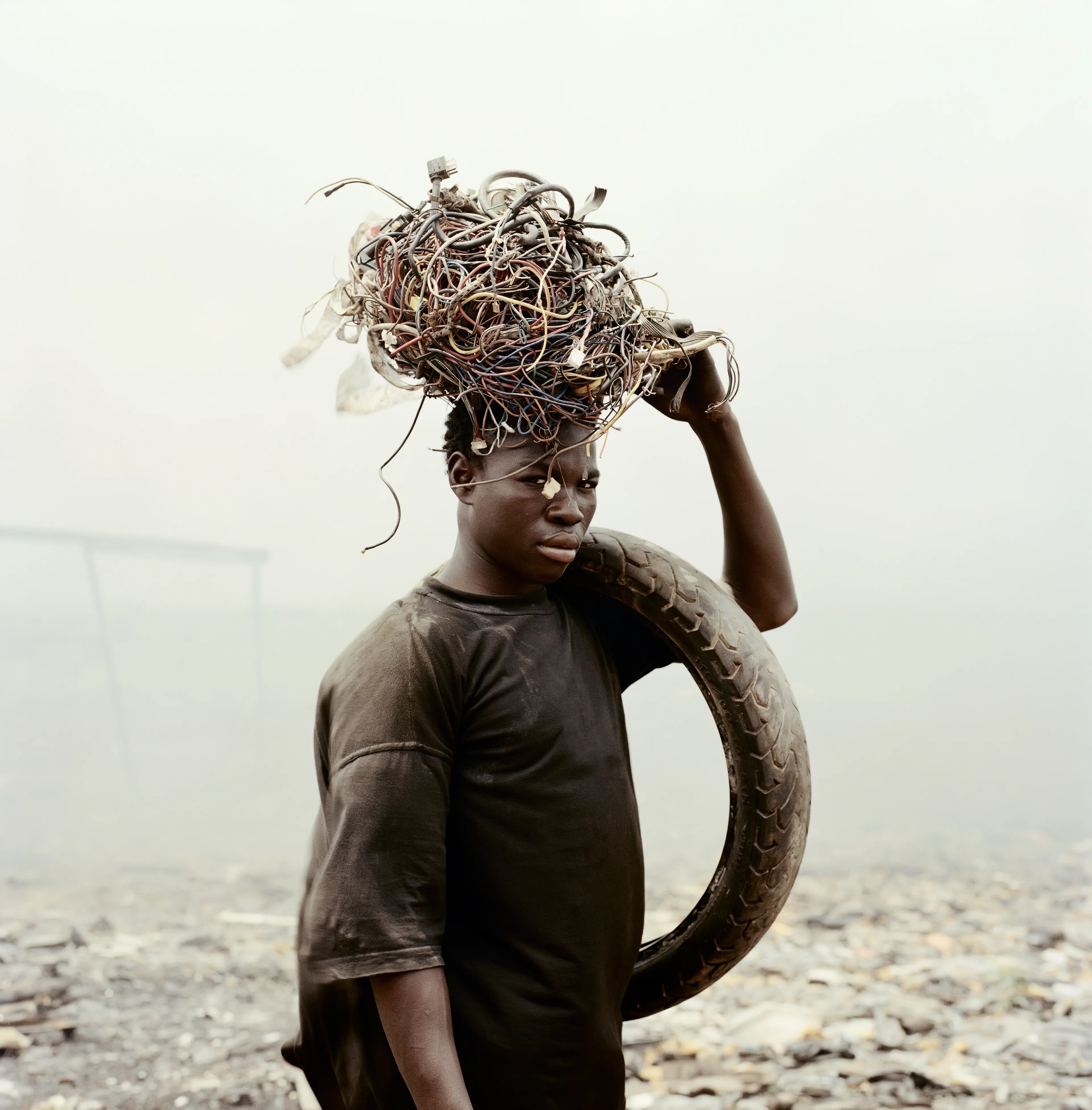 "This essay was photographed on a densely populated triangle of land in the Ghanaian capital of Accra. Bounded by the Abossey Okai Road and Odaw River, a polluted waterway that flows into the Korle Lagoon, Agbogbloshie is the second largest e-waste processing area in West Africa. It abuts Old Fadama, an impoverished settlement that offers northern migrants to the city the cheapest rents and a convenient base close to the central markets, a major employer. Home to an estimated 80 000 inhabitants, this mixed-used area on a former wetland consists not only of formal and informal residences for disenfranchised migrants to the city, but a commercial bus depot, and a vast and differentiated marketplace that includes specialised e-waste markets. An irregular activity until a few years ago, large volumes of end-of-life computers and television are now handled by Ghana’s port daily. Shipped under pretext of being reusable electronic goods, items that are not saleable end up at Agbogbloshie, nicknamed by locals as ‘Sodom and Gomorrah’.

It is here that circuits, transistors, capacitors and semiconductors are reduced to their base metals. There is, one has to admit, something beautifully alchemical about what’s happening there: these devices that are the pinnacle of cultural achievement get transformed back into their base elements. Of course, this is the sympathetic reading of an artist. The political ecologist Paul Robbins has described the dump as ‘a bizarre engine that maintains a self-replicating worldwide system of over-production’. I think it is fair to say that Agbogbloshie is a dark and dirty monument to the digital age, to our faith in technology and its built-in obsolescence. This idea of surplus and waste, which is key to our digital experience, is not one that many people seem comfortable addressing. Being in an environment like this, where geopolitical imbalances are being exploited to effectively dump waste on poor countries, it is hard not to take a political position. And so I have let my photographs be used by advocacy groups.

I first encountered the dump in a photograph published by National Geographic. This is a recurrent theme in my photography, how photographs prompt me to make my own photographs. The work was produced during two trips of two weeks each. I tend to photograph over two-week stretches. I find this is a period in which I can keep my eye fresh. After that you become too accustomed to a place. It was something I realised in Rwanda, how quickly one becomes desensitised and acclimatised to completely unacceptable situations, how the mind is capable of this". -  Pieter Hugo

Edition: 1 of 1