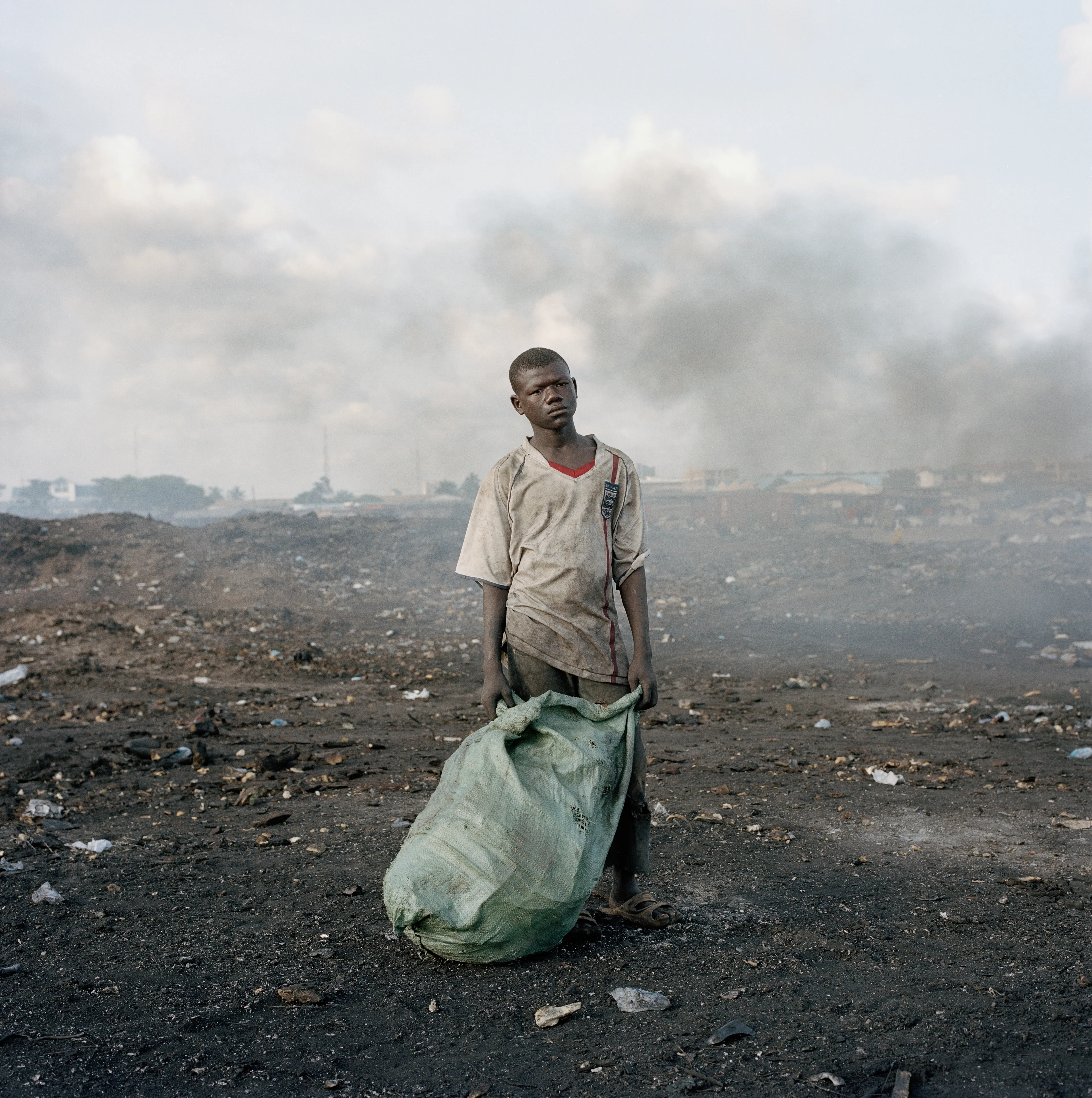 "This essay was photographed on a densely populated triangle of land in the Ghanaian capital of Accra. Bounded by the Abossey Okai Road and Odaw River, a polluted waterway that flows into the Korle Lagoon, Agbogbloshie is the second largest e-waste processing area in West Africa. It abuts Old Fadama, an impoverished settlement that offers northern migrants to the city the cheapest rents and a convenient base close to the central markets, a major employer. Home to an estimated 80 000 inhabitants, this mixed-used area on a former wetland consists not only of formal and informal residences for disenfranchised migrants to the city, but a commercial bus depot, and a vast and differentiated marketplace that includes specialised e-waste markets. An irregular activity until a few years ago, large volumes of end-of-life computers and television are now handled by Ghana’s port daily. Shipped under pretext of being reusable electronic goods, items that are not saleable end up at Agbogbloshie, nicknamed by locals as ‘Sodom and Gomorrah’.

It is here that circuits, transistors, capacitors and semiconductors are reduced to their base metals. There is, one has to admit, something beautifully alchemical about what’s happening there: these devices that are the pinnacle of cultural achievement get transformed back into their base elements. Of course, this is the sympathetic reading of an artist. The political ecologist Paul Robbins has described the dump as ‘a bizarre engine that maintains a self-replicating worldwide system of over-production’. I think it is fair to say that Agbogbloshie is a dark and dirty monument to the digital age, to our faith in technology and its built-in obsolescence. This idea of surplus and waste, which is key to our digital experience, is not one that many people seem comfortable addressing. Being in an environment like this, where geopolitical imbalances are being exploited to effectively dump waste on poor countries, it is hard not to take a political position. And so I have let my photographs be used by advocacy groups.

I first encountered the dump in a photograph published by National Geographic. This is a recurrent theme in my photography, how photographs prompt me to make my own photographs. The work was produced during two trips of two weeks each. I tend to photograph over two-week stretches. I find this is a period in which I can keep my eye fresh. After that you become too accustomed to a place. It was something I realised in Rwanda, how quickly one becomes desensitised and acclimatised to completely unacceptable situations, how the mind is capable of this". -  Pieter Hugo

Edition: 1 of 1