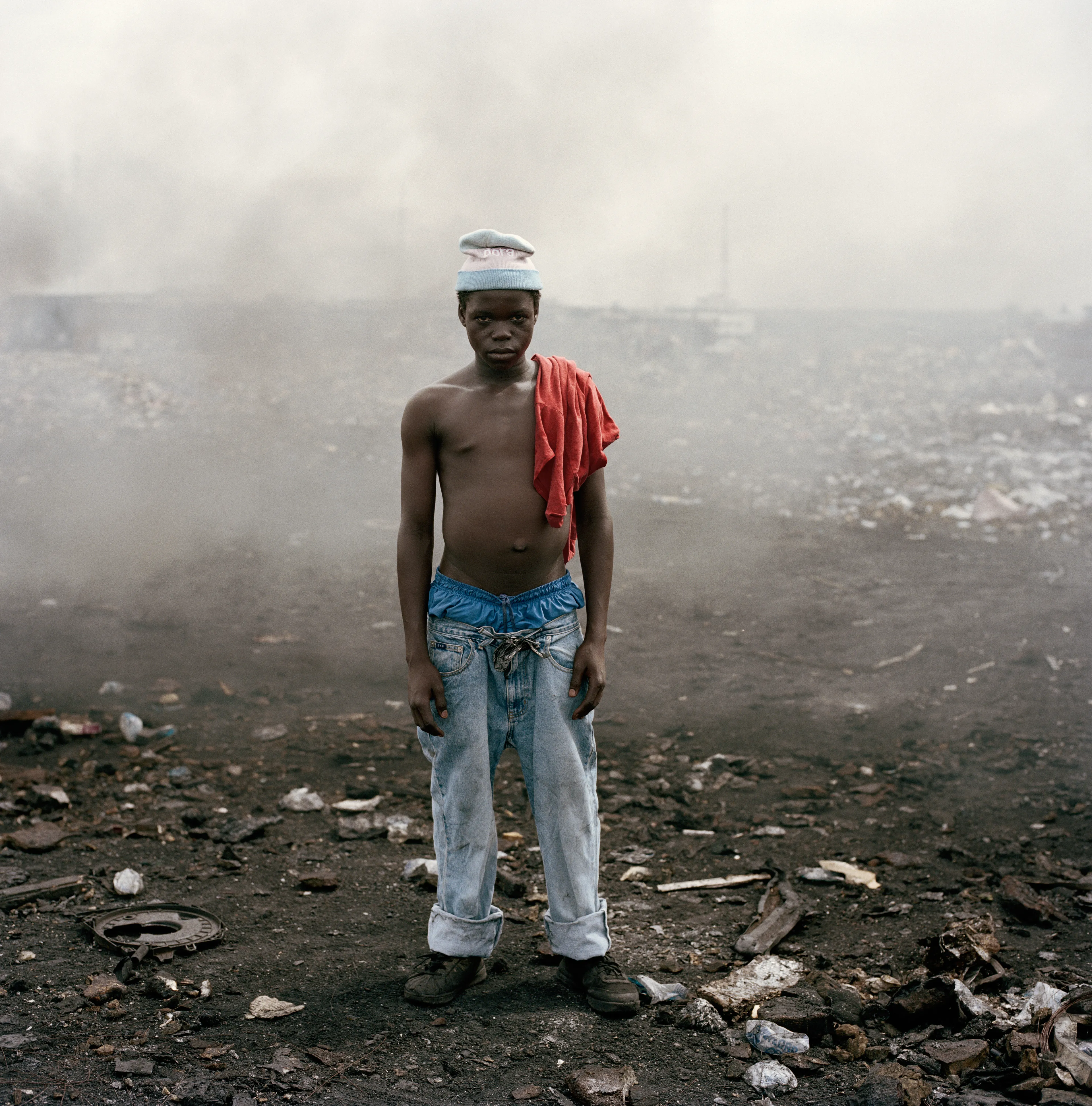 "This essay was photographed on a densely populated triangle of land in the Ghanaian capital of Accra. Bounded by the Abossey Okai Road and Odaw River, a polluted waterway that flows into the Korle Lagoon, Agbogbloshie is the second largest e-waste processing area in West Africa. It abuts Old Fadama, an impoverished settlement that offers northern migrants to the city the cheapest rents and a convenient base close to the central markets, a major employer. Home to an estimated 80 000 inhabitants, this mixed-used area on a former wetland consists not only of formal and informal residences for disenfranchised migrants to the city, but a commercial bus depot, and a vast and differentiated marketplace that includes specialised e-waste markets. An irregular activity until a few years ago, large volumes of end-of-life computers and television are now handled by Ghana’s port daily. Shipped under pretext of being reusable electronic goods, items that are not saleable end up at Agbogbloshie, nicknamed by locals as ‘Sodom and Gomorrah’.

It is here that circuits, transistors, capacitors and semiconductors are reduced to their base metals. There is, one has to admit, something beautifully alchemical about what’s happening there: these devices that are the pinnacle of cultural achievement get transformed back into their base elements. Of course, this is the sympathetic reading of an artist. The political ecologist Paul Robbins has described the dump as ‘a bizarre engine that maintains a self-replicating worldwide system of over-production’. I think it is fair to say that Agbogbloshie is a dark and dirty monument to the digital age, to our faith in technology and its built-in obsolescence. This idea of surplus and waste, which is key to our digital experience, is not one that many people seem comfortable addressing. Being in an environment like this, where geopolitical imbalances are being exploited to effectively dump waste on poor countries, it is hard not to take a political position. And so I have let my photographs be used by advocacy groups.

I first encountered the dump in a photograph published by National Geographic. This is a recurrent theme in my photography, how photographs prompt me to make my own photographs. The work was produced during two trips of two weeks each. I tend to photograph over two-week stretches. I find this is a period in which I can keep my eye fresh. After that you become too accustomed to a place. It was something I realised in Rwanda, how quickly one becomes desensitised and acclimatised to completely unacceptable situations, how the mind is capable of this". -  Pieter Hugo

Edition: 1 of 1