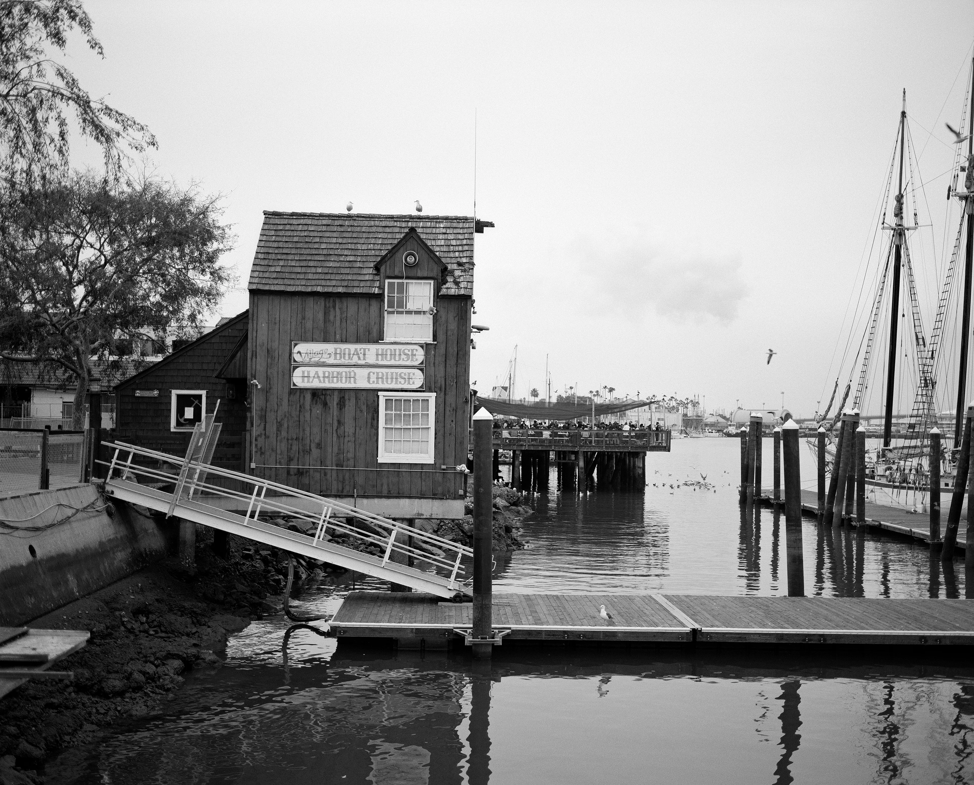 THE VILLAGE #33 VIEW OF HARBOR HOUSE by Deanna Templeton

This project started in 2002. A year after my mother passed away, a few years after my father passed. What I remember was one day I was thinking about my parents and feeling a little bit lonely, a little empty and decided to go for a drive. So I decided to drive out to my grandmother's house in San Pedro, which is about a 45 minute drive from where I live. I just wanted to reminisce, to re-explore the surroundings where I would go when I was a child. The liquor store I would walk to to get a Lipton Ice Tea and a bag of Frito’s, to the bakery where I swore all the cookies didn’t have sugar in them and then I drove over to Ports O’Call Village. As soon as I started to walk around I came across a stage with some Mariachis playing and it just hit me, I felt like I was home, I was with family. Over the next 5 years, whenever I could, I started going out there on the weekends. Getting reacquainted with the village and the locals. To shoot everything I wanted to remember.

Edition: 1 of 1

Commissioned by Obscura