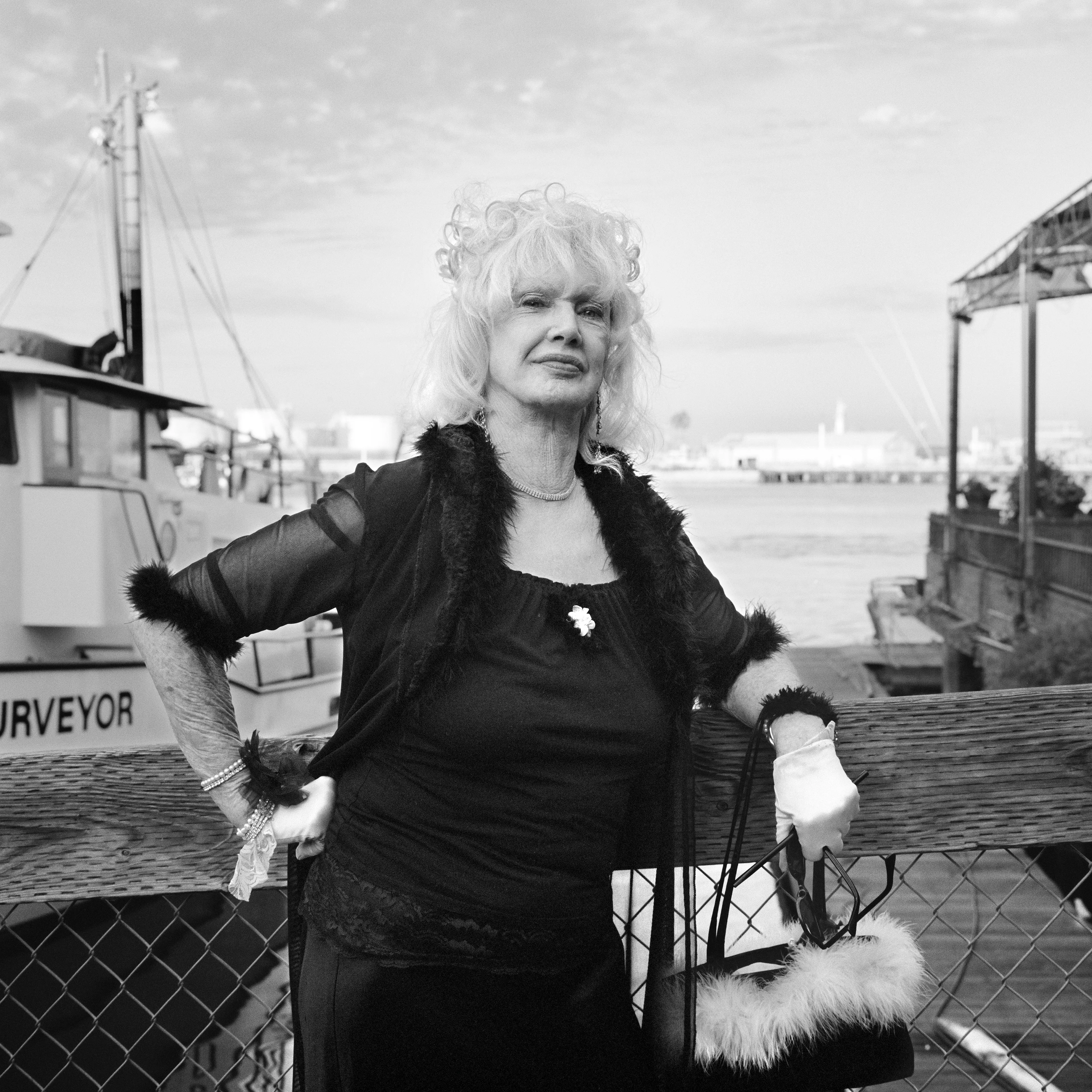 THE VILLAGE #15 PORTRATI OF WOMAN WEARING GLOVES by Deanna Templeton

This project started in 2002. A year after my mother passed away, a few years after my father passed. What I remember was one day I was thinking about my parents and feeling a little bit lonely, a little empty and decided to go for a drive. So I decided to drive out to my grandmother's house in San Pedro, which is about a 45 minute drive from where I live. I just wanted to reminisce, to re-explore the surroundings where I would go when I was a child. The liquor store I would walk to to get a Lipton Ice Tea and a bag of Frito’s, to the bakery where I swore all the cookies didn’t have sugar in them and then I drove over to Ports O’Call Village. As soon as I started to walk around I came across a stage with some Mariachis playing and it just hit me, I felt like I was home, I was with family. Over the next 5 years, whenever I could, I started going out there on the weekends. Getting reacquainted with the village and the locals. To shoot everything I wanted to remember.

Edition: 1 of 1

Commissioned by Obscura