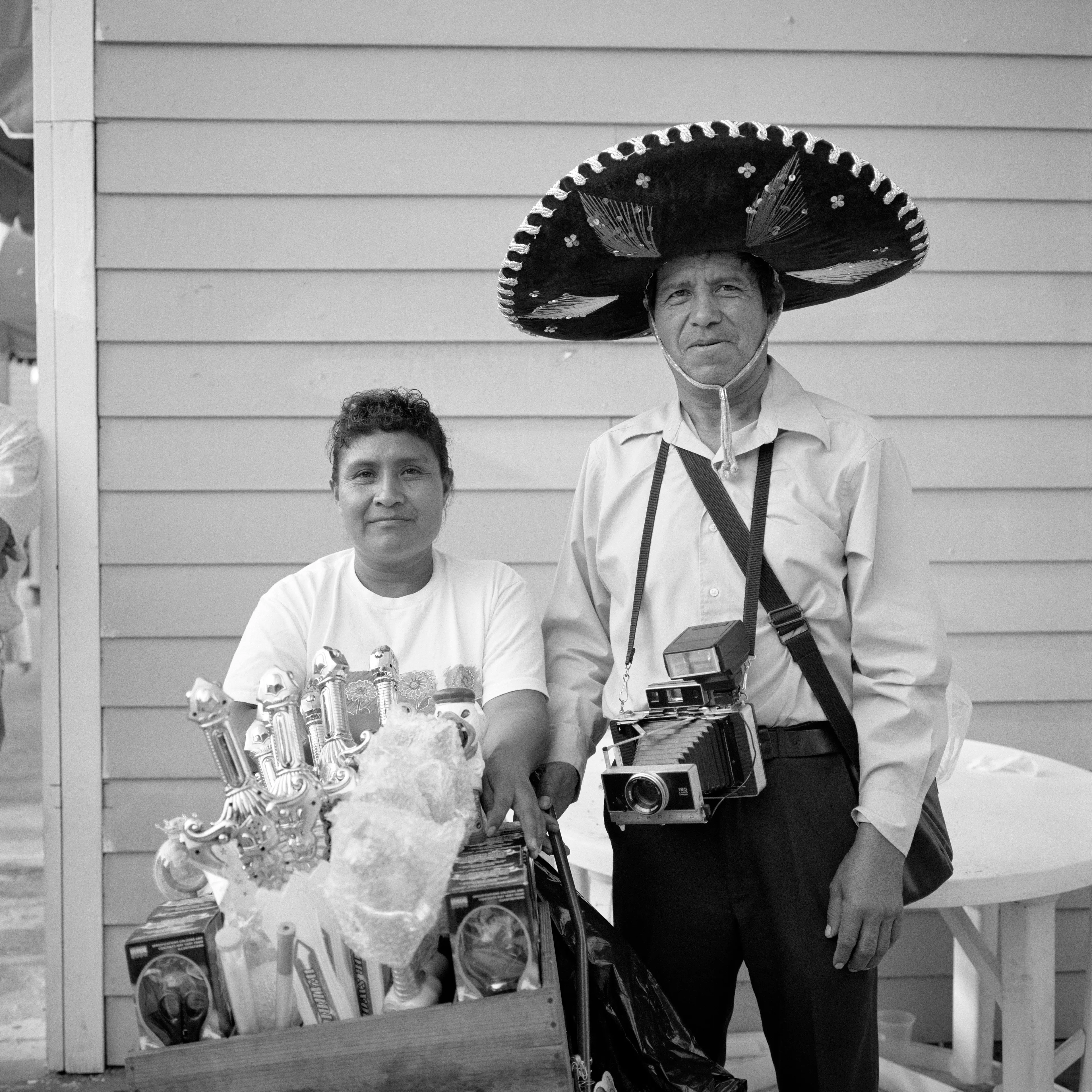 THE VILLAGE #8 MAN WITH CAMERA WOMAN SELLING TRINKETS by Deanna Templeton

This project started in 2002. A year after my mother passed away, a few years after my father passed. What I remember was one day I was thinking about my parents and feeling a little bit lonely, a little empty and decided to go for a drive. So I decided to drive out to my grandmother's house in San Pedro, which is about a 45 minute drive from where I live. I just wanted to reminisce, to re-explore the surroundings where I would go when I was a child. The liquor store I would walk to to get a Lipton Ice Tea and a bag of Frito’s, to the bakery where I swore all the cookies didn’t have sugar in them and then I drove over to Ports O’Call Village. As soon as I started to walk around I came across a stage with some Mariachis playing and it just hit me, I felt like I was home, I was with family. Over the next 5 years, whenever I could, I started going out there on the weekends. Getting reacquainted with the village and the locals. To shoot everything I wanted to remember.

Edition: 1 of 1

Commissioned by Obscura