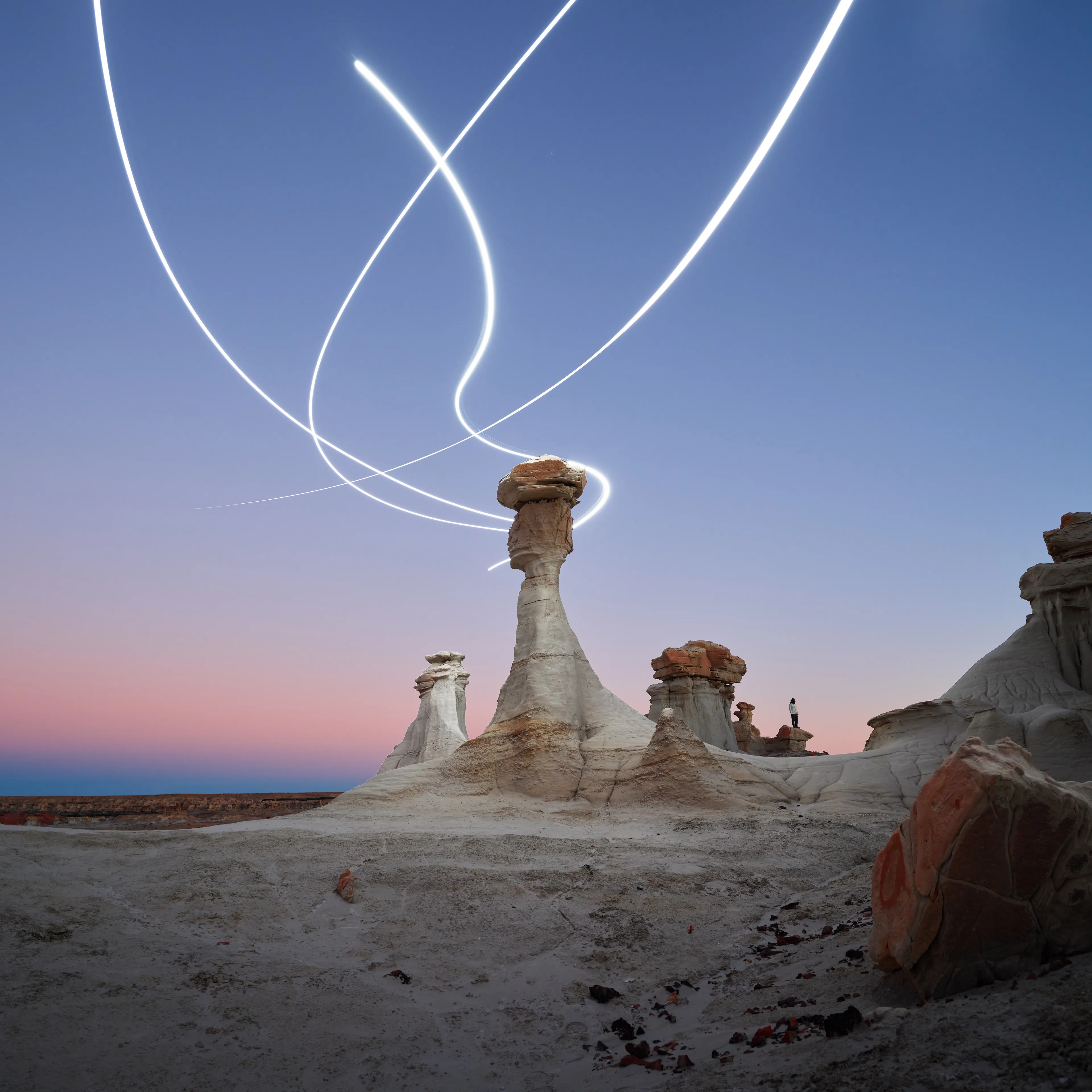 Aeroglyph Variations #19 by Reuben Wu

Aeroglyph Variations is a collection evolved from my Aeroglyphs body of work, created exclusively for Obscura Curated. 

Aeroglyphs explores my method of intervention in landscape photography. By using light carrying drones and long exposure, I’m able to play a larger role in artistic expression all without leaving a trace on the scene.

This series was captured over the course of 20 hours in New Mexico, USA on Dec 12-13 2021. It shows the iterative processes and decisions I typically encounter during the creation of a final image, presented as a collection of 55 images. Compositionally, every image is the same, yet in attributes, every image is different. Time of day, light formations (glyphs) and other traits vary within the series to result in a spectrum of unique possibilities.

Taking inspiration from generative art and groundbreaking photo projects such as Carpoolers (Alejandro Cartagena), this project examines the notion of the photographer as algorithm; the code that creates and which ultimately derives from our unique programming of life experiences.
Reuben Wu's OpenSea: https://opensea.io/itsreuben?tab=created

Edition: 1 of 1

Commissioned by Obscura