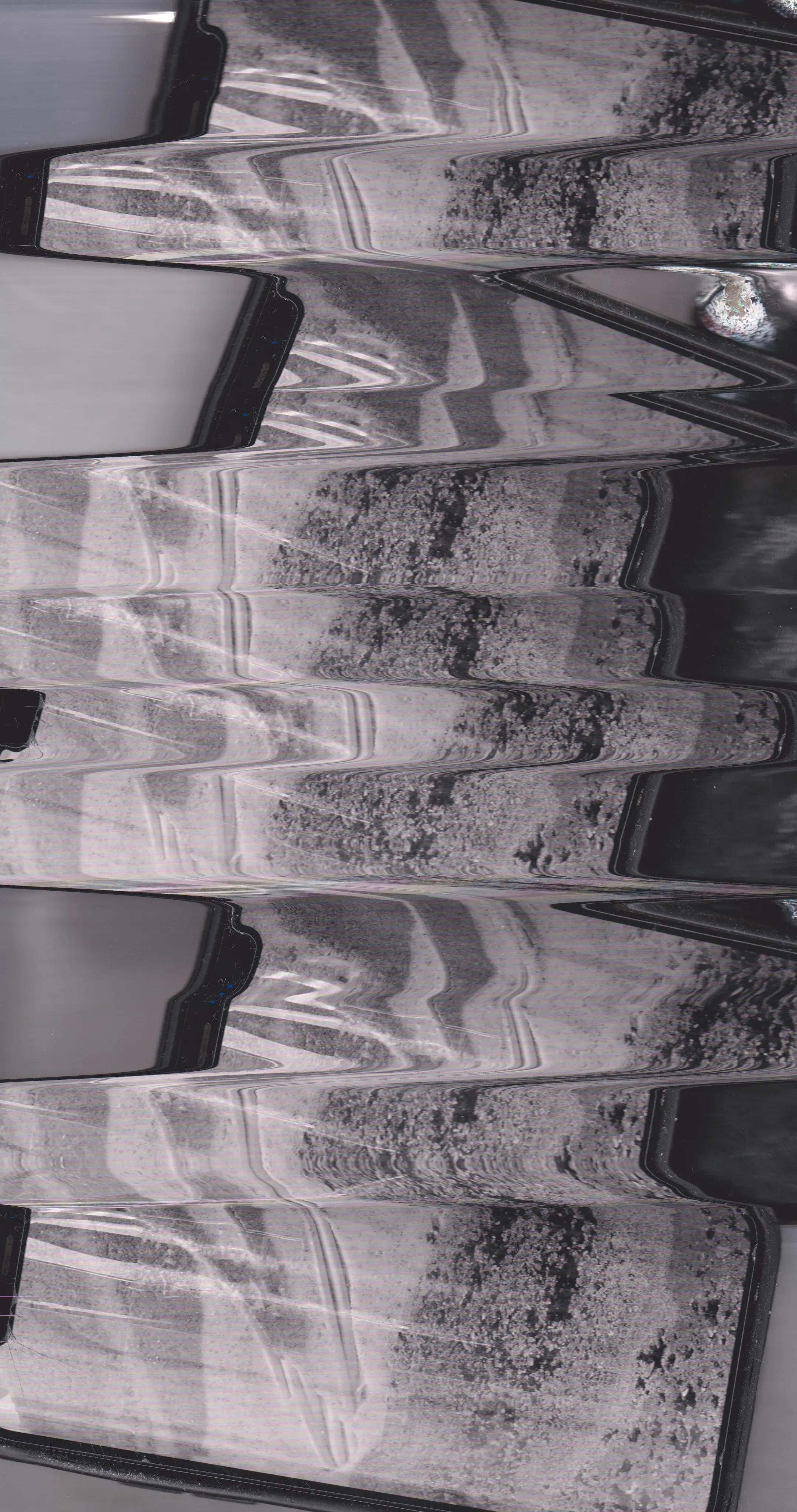 Flatbed scanner. iPhone. Photograph of layered sand and e-waste.
