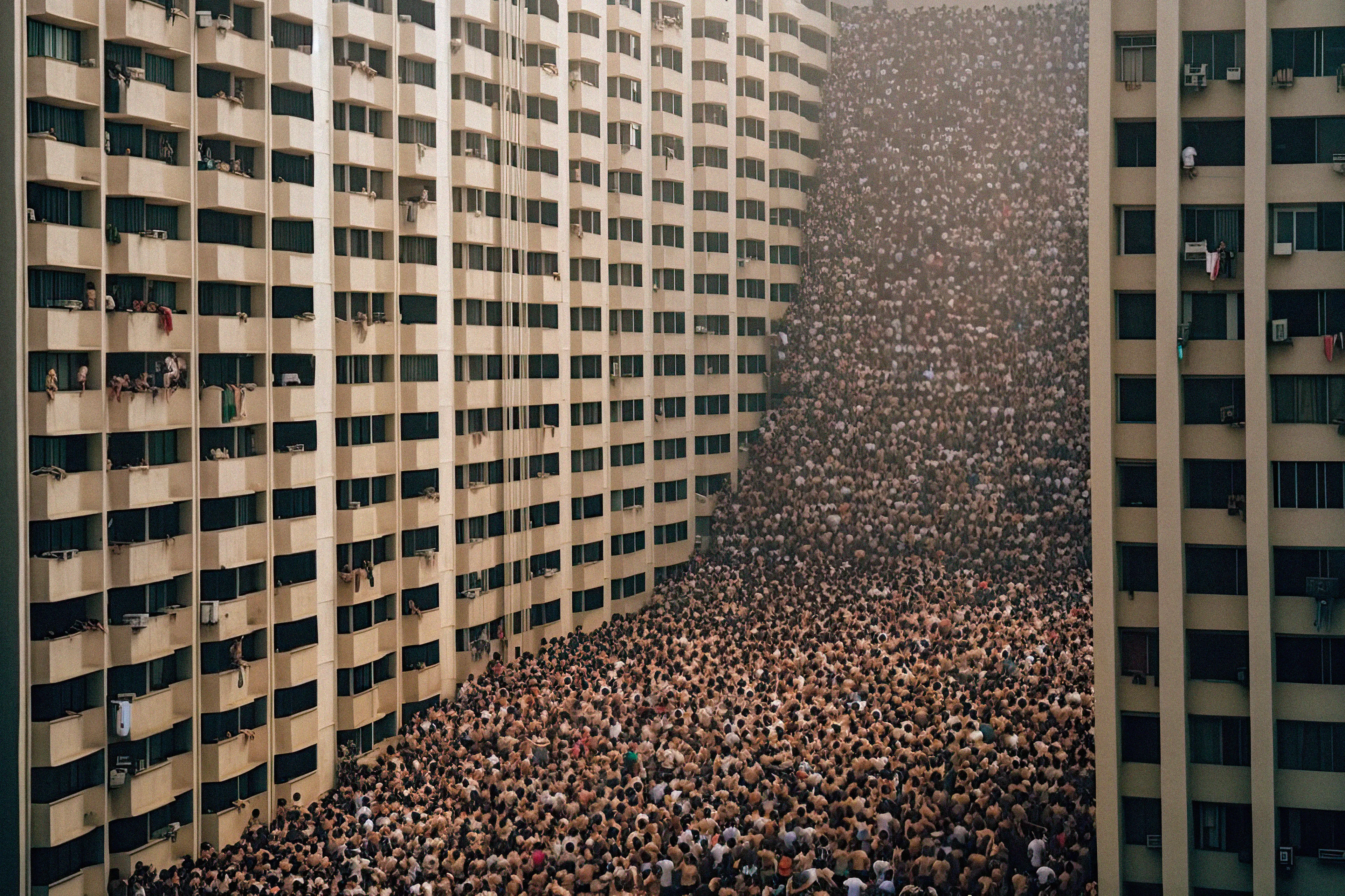 "Overpopulated Symphonies" is a collection of AI post-photography that immerses viewers in a commentary on the contemporary human condition. Through sprawling images of densely populated urban landscapes and human gatherings, the collection reduces individuals to minuscule points, forming an overwhelming sea of indistinguishable dots.

Beyond the literal portrayal of overpopulation, this collection utilizes the metaphor of crowd density as an analogy for the inundation of information in our modern era. It poses questions about identity, individuality, and the struggles faced by the human mind in processing and prioritizing the relentless surge of data we encounter daily. The figures in these photographs transcend mere physical bodies; they represent thoughts, ideas, and information, all vying for recognition and space within the confines of our mental landscapes. With humans depicted as dots in a chaotic neural network, these artworks serve as an allegory for the phenomenon of information overload.

The title "Overpopulated Symphonies" intends to evoke the intricate and often overwhelming nature of our current reality. "Overpopulated" alludes to the physical density of human gatherings depicted in the collection, but also metaphorically refers to the overflow of information and ideas that bombard us incessantly. The term "Symphonies" suggests a sense of harmony and order, offering an optimistic counterpoint to the chaos portrayed. It hints at the potential for synchronicity to arise from apparent disarray.