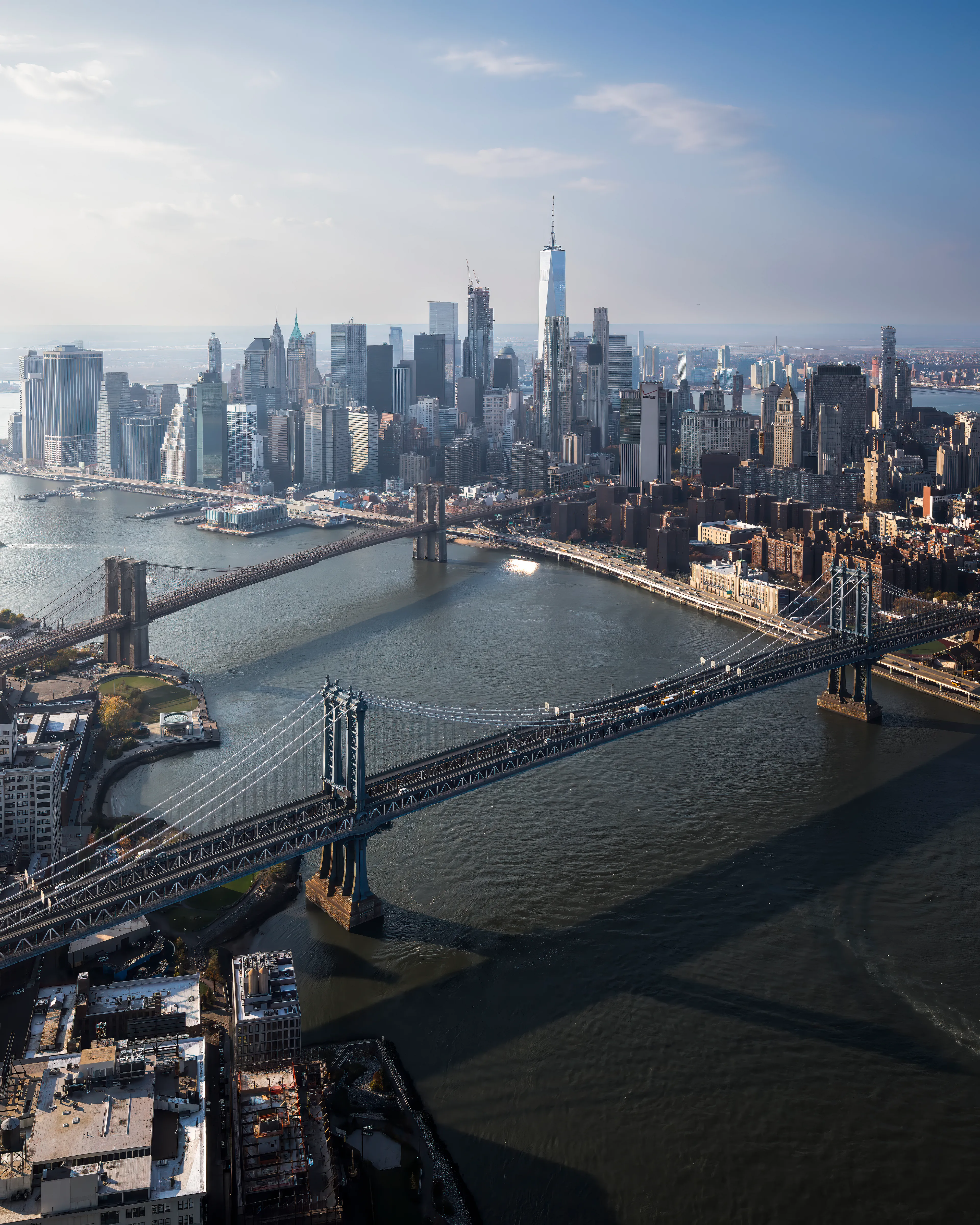 There is a quality to the light in New York in late autumn that lends itself to my style of photography.  Far reaching light,  clean, crisp air, and Long shadows.  As the short afternoons turn towards sunset, these traits are magnified.  Our pilot had to maneuver a little further east than we normally would, and because of that, this frame was revealed.  The Manhattan and Brooklyn bridges in alignment with the still relatively new Freedom Tower.  All of that would have been enough for a good frame, but the shadows are what really made this image for me.  As we moved north along the river, I tried to keep my framing, and exposures consistent to highlight all these elements.