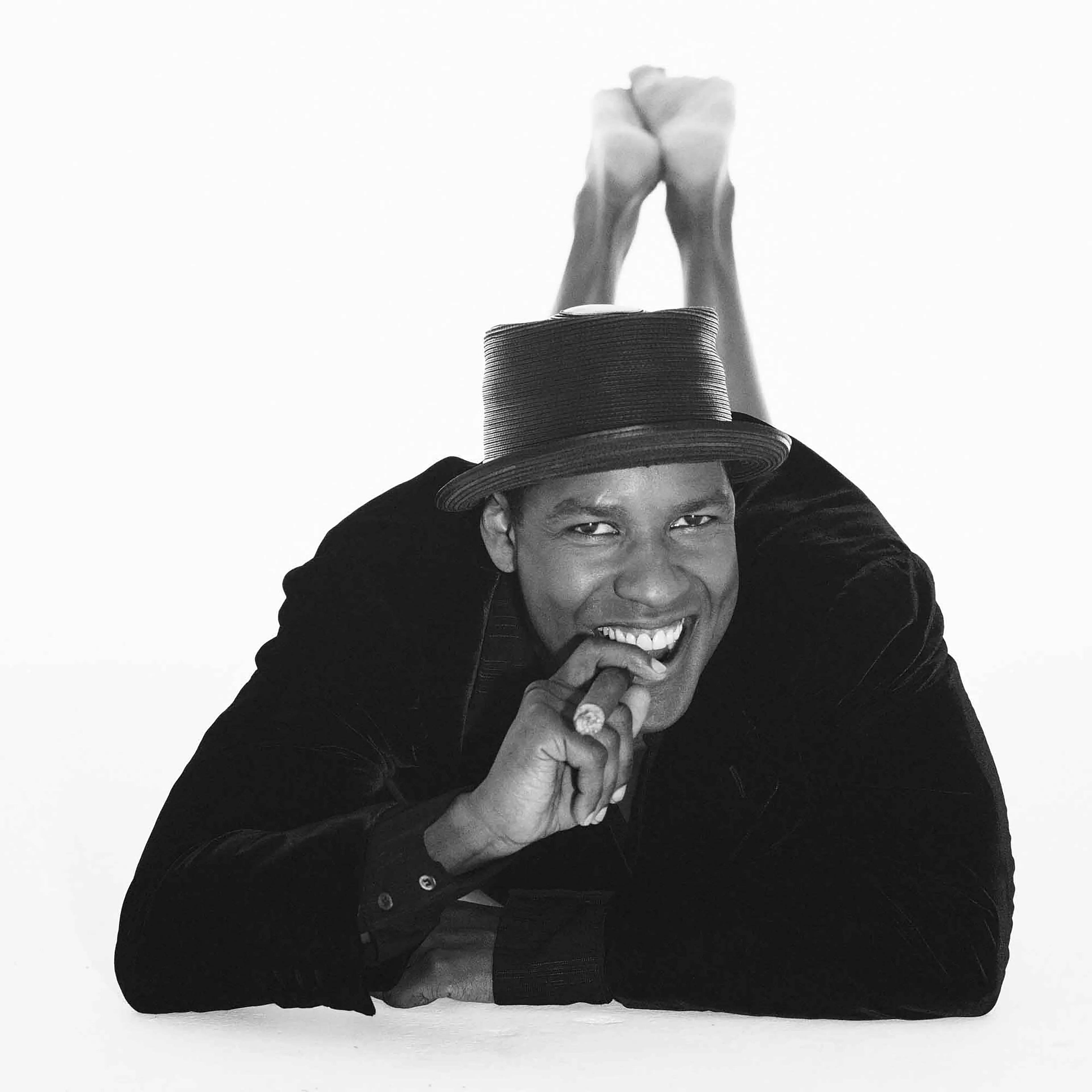 Denzel Washington, 1998, Hollywood Studio for Cigar Aficionado

"I don’t want to sit around talking about myself. That’s not a great day for me. That’s not my idea of fun. I guess I’m always looking for new challenges. That’s who I am. It’s not necessarily being identified as an actor or movie star. One is not better than the others. It’s just as an actor I choose to play a lot of different kinds of parts and I enjoy that. I think that’s what acting is."

Honestly have you ever seen Denzel Washington with such exuberant boyish energy?
It was a day of loose and unstructured craziness, taking picture after picture of Denzel being outside any of his acting characters. He just wanted to have fun…and for us it was great Fun.

—-----------------
Collector Bonuses:

The winning collector of this 1-of-1 auctioned NFT will be eligible to receive a signed and dated museum-quality archival print that’s either 28x28 inches or 23x28 inches, depending on the cropping. The print will be shipped in a tube, along with a signed, dated and titled Certificate of Authenticity. 

The winning collector will also be eligible to receive a special bonus NFT from the artist that will be airdropped within 96 hours or more after winning this piece. 

*For shipment of the physical print, please allow 6-8 weeks for delivery.