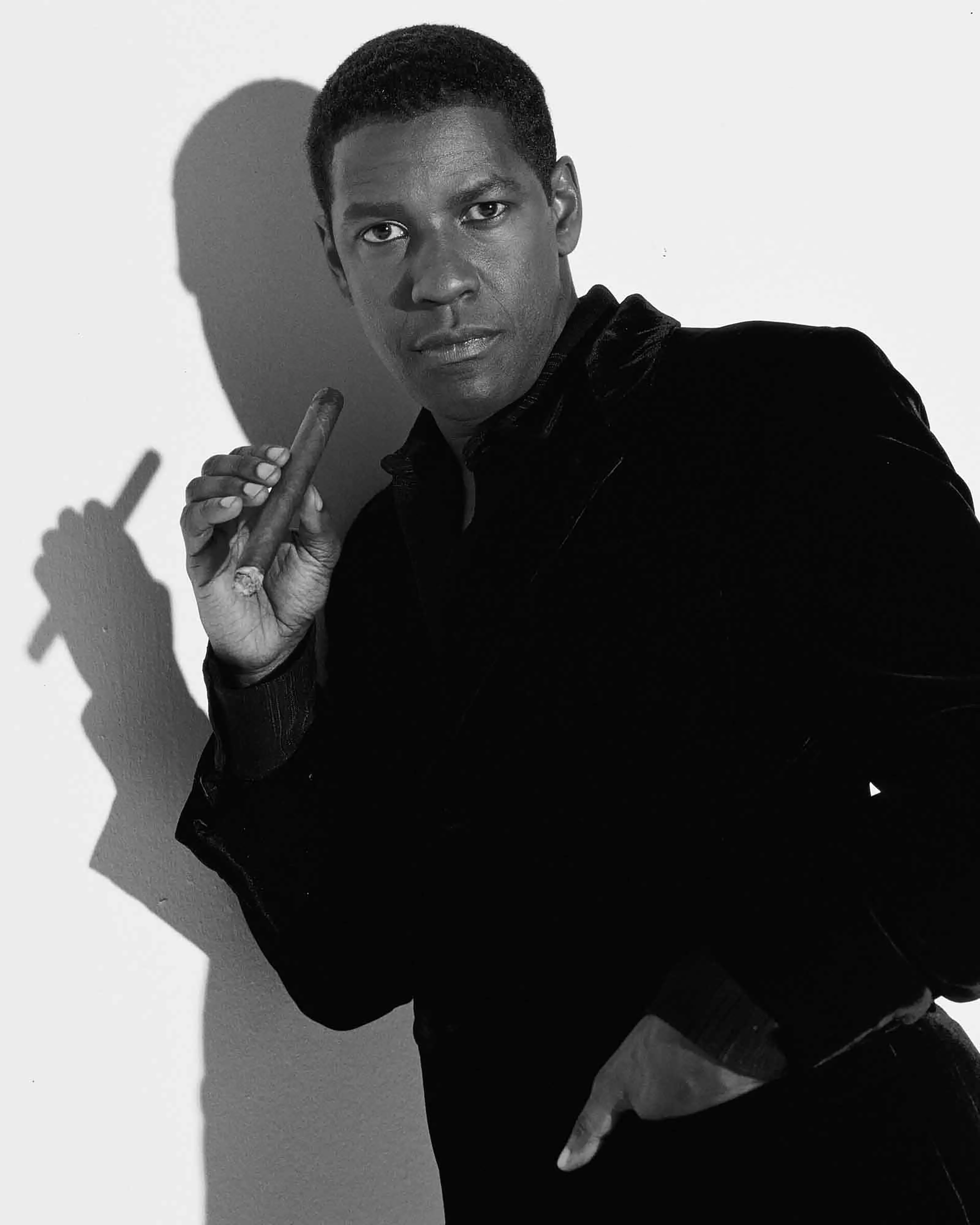 Denzel Washington, 1998, Hollywood Studio for Cigar Aficionado. 

He has been described as an actor who reconfigured “the concept of classic movie stardom for his performances on the screen and stage.”

This is one of the few "serious" pictures from my  day with Denzel. His movie persona is tough, committed, serious, dramatic and varied.

Today he was a comedian, the first and only time I’ve ever seen pictures of Denzel Washington clownishly laying on a studio floor, standing in the center of the studio stage mimicking comedians of 40 years earlier, or dressed in white holding his naked toes.

Here is the classic Denzel. It was a once in a lifetime experience.

*This artwork piece is a special collector’s bonus*
