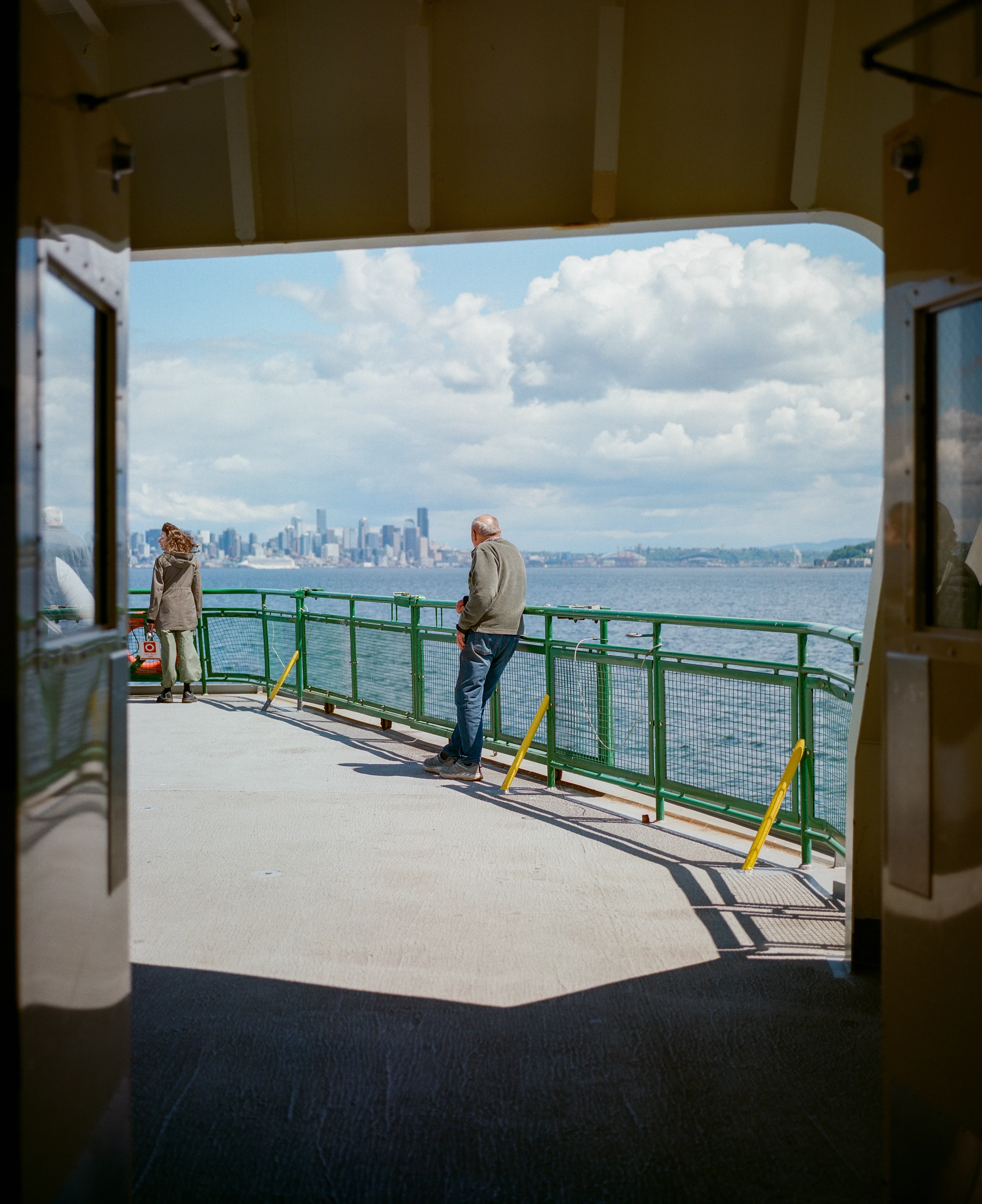 A passenger steps outside to enjoy some fresh air and sunshine en route to downtown Seattle.
