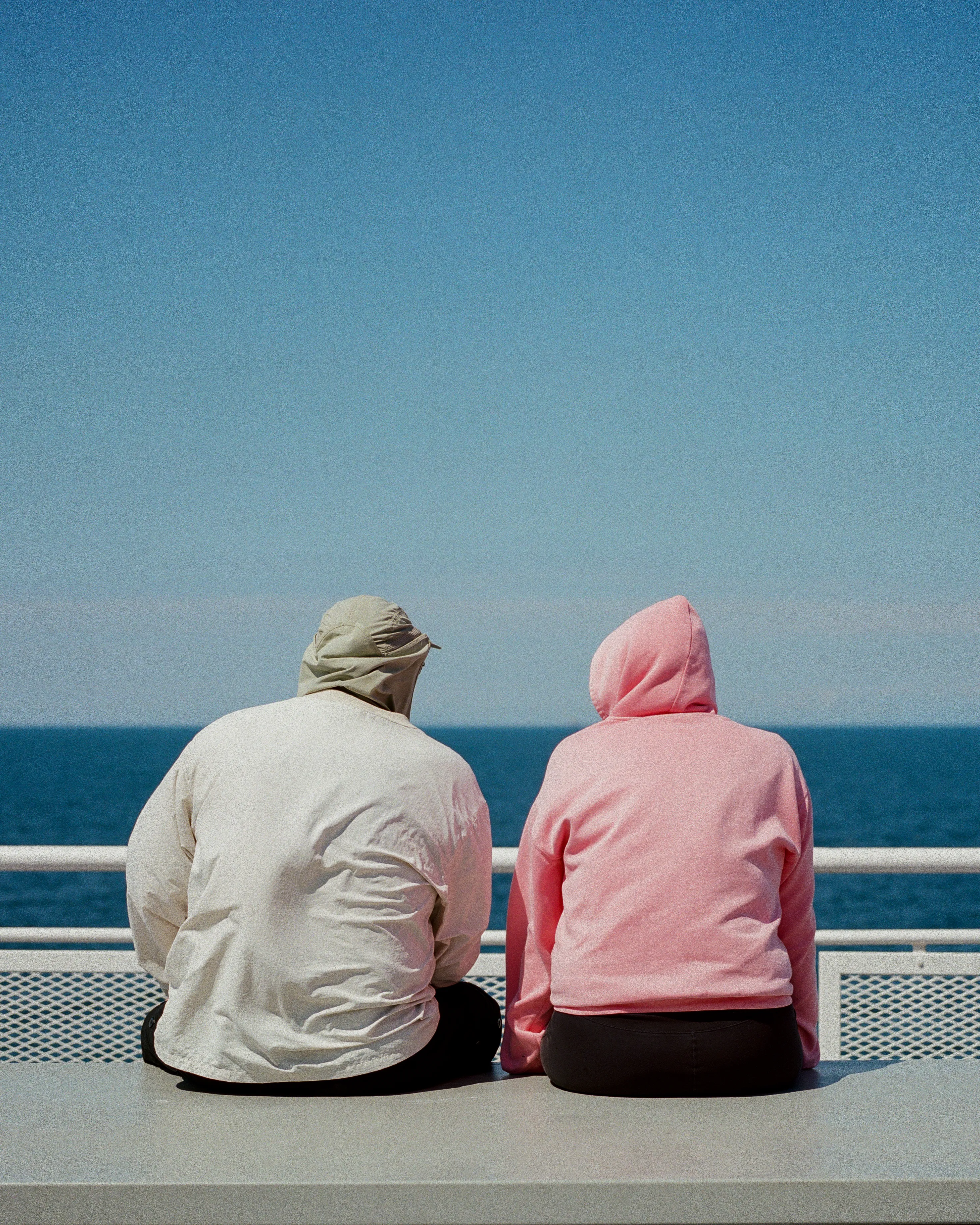 A couple enjoys the sunshine on the outdoor deck, heading back from Vancouver Island.