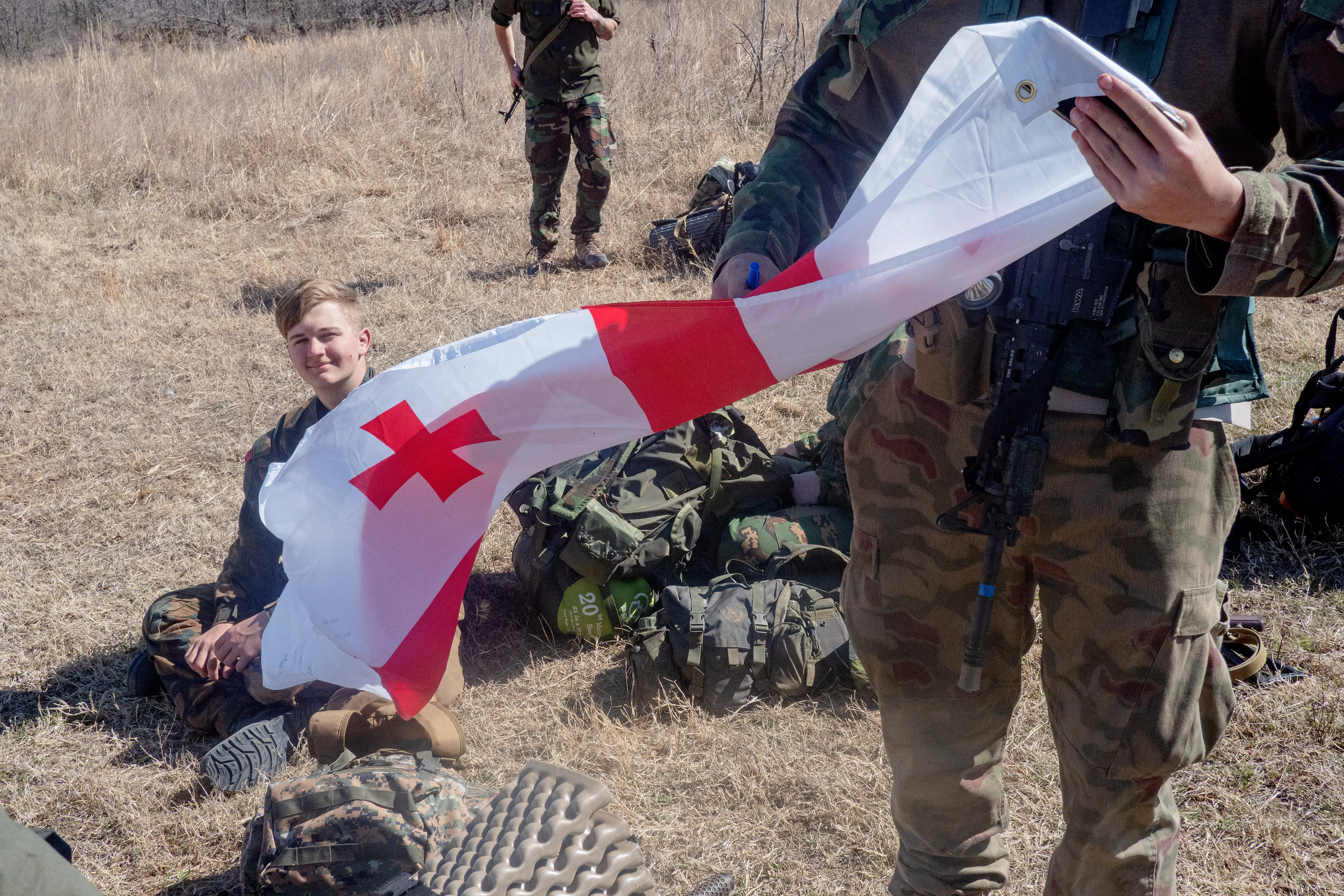 USA. Oklahoma. Overbrook. Battle Springs Ranch. March 2022. Russfor actor with a Georgian flag he figured should be part of the anti-Nato coalition. Final battle. Russian troops take a building from NATO forces and "win". Milsim, military simulation, airsoft weekend full immersion event. In a scenario where US and NATO troops, after loosing the battle of Kharkiv are trying to take back the Russian garrison town of Sarsk in the Rostov region close to the Ukrainian border. US FOR versus RUS FOR. Milsim West has been reenacting similar scenarios for a dozen of years and the similarity to current events is coincidental.