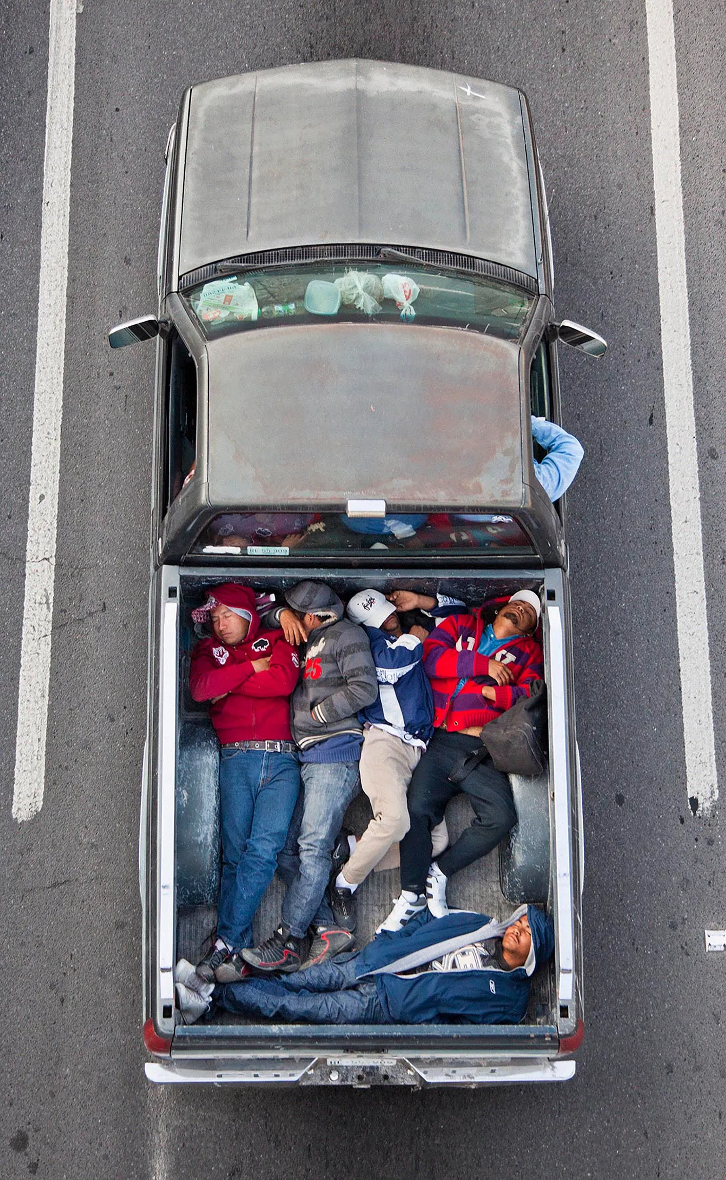 This photograph is part of my series, Carpoolers, which depicts laborers in México captured from an overpass, commuting between distant suburbs and urban centers. Like much of my work, this project comes from a desire to tell the story of the dramatic economic, environmental, and demographic changes playing out in my home city of Monterrey. This series has circulated the internet since 2011 and has been exhibited widely around the world.