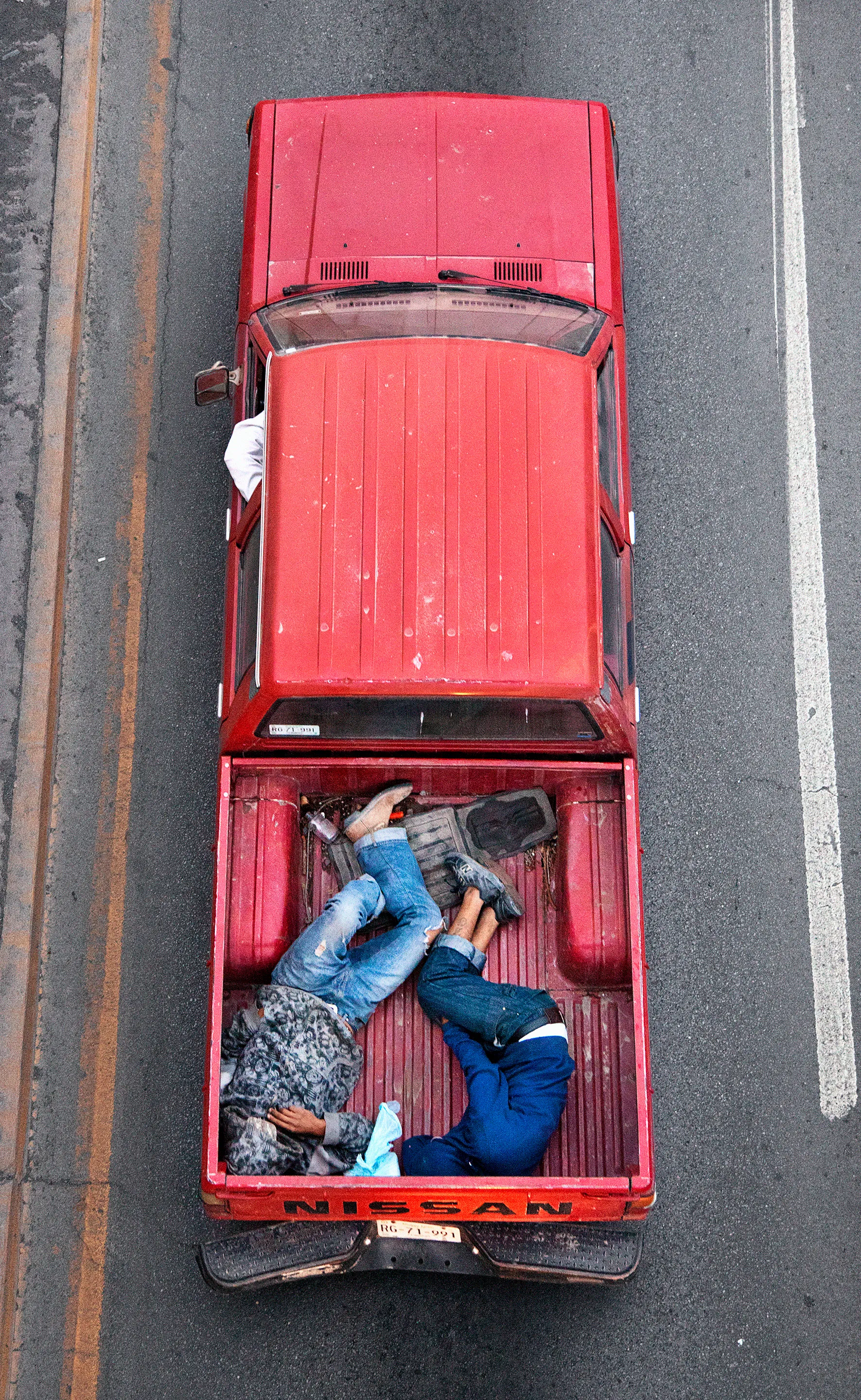 This photograph is part of my series, Carpoolers, which depicts laborers in México captured from an overpass, commuting between distant suburbs and urban centers. Like much of my work, this project comes from a desire to tell the story of the dramatic environmental, economic, and demographic changes playing out in my home city of Monterrey. This series has circulated the internet since 2011 and has been exhibited widely around the world. This piece is part of a collection of 50 works.