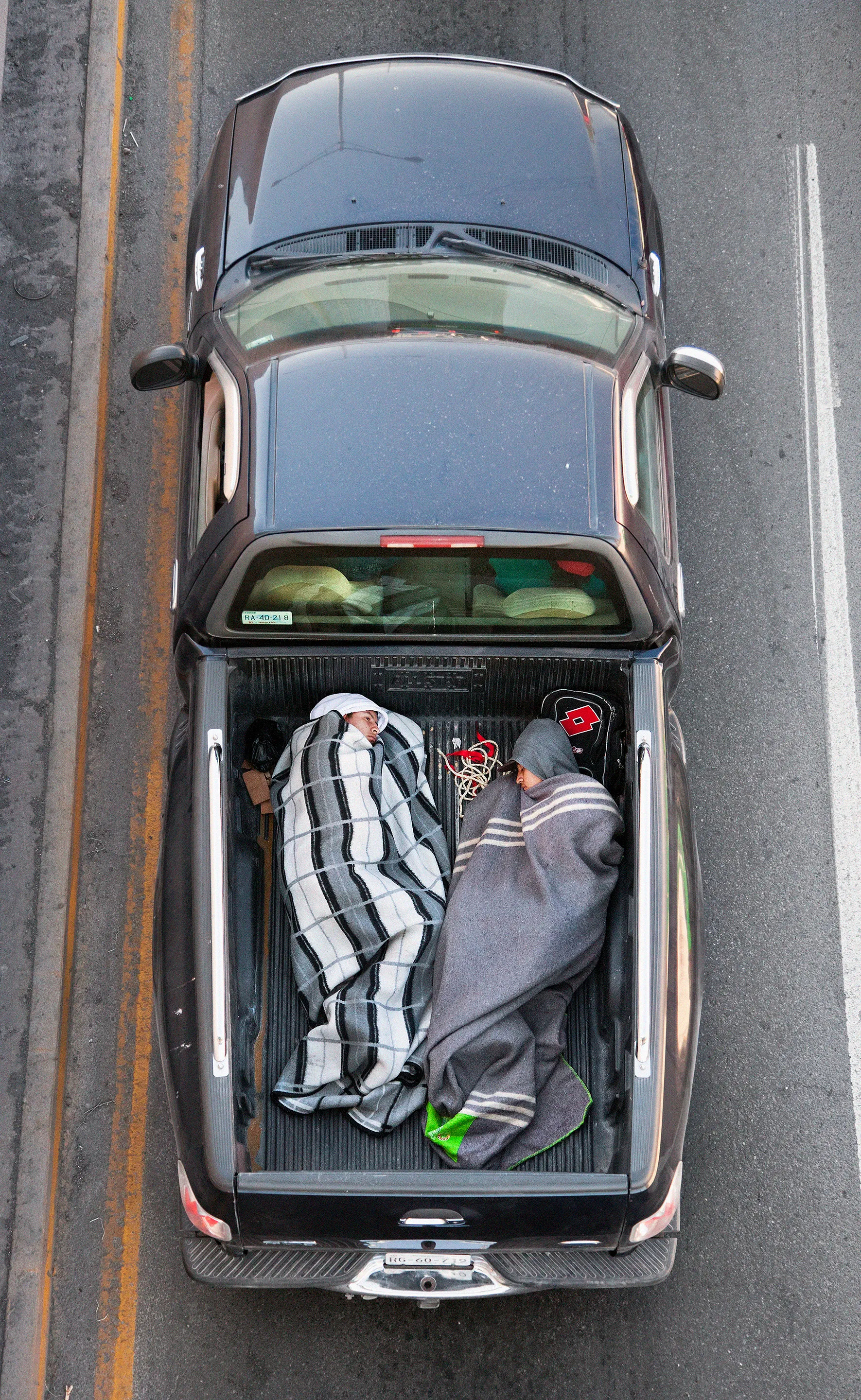 This photograph is part of my series, Carpoolers, which depicts laborers in México captured from an overpass, commuting between distant suburbs and urban centers. Like much of my work, this project comes from a desire to tell the story of the dramatic environmental, economic, and demographic changes playing out in my home city of Monterrey. This series has circulated the internet since 2011 and has been exhibited widely around the world. This piece is part of a collection of 50 works.