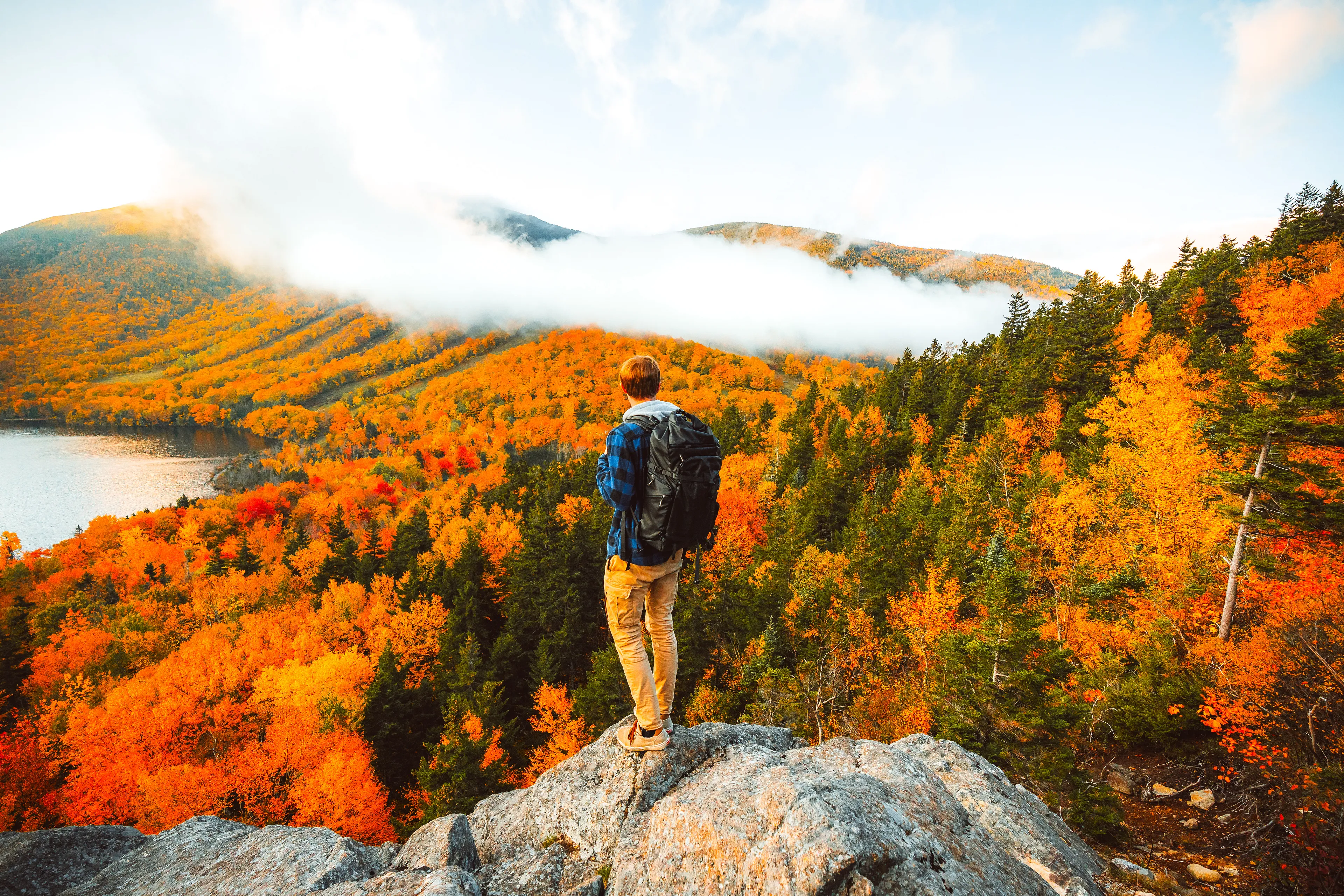 I have always been one to emphasize the value of dedication in photography; putting in the extra mile and waking up early if you are truly determined to get the photo you have in mind.

For this particular image, I woke up at 4 AM to drive 2 hours north into the mountains of New Hampshire. I hiked a fairly popular trail for sunrise, and upon reaching the summit, I looked for a way to distance myself from the crowds and find a unique vantage point. 

This small rock outcropping ended up being exactly what I was looking for. It provided an excellent view of the foliage as well as the cloud system making its way through the valley. 

This piece is true to its name, as it showcases one of the most vivid displays of fall color I’ve seen in my life time. The fiery oranges and reds ignite my soul and passion to explore.  