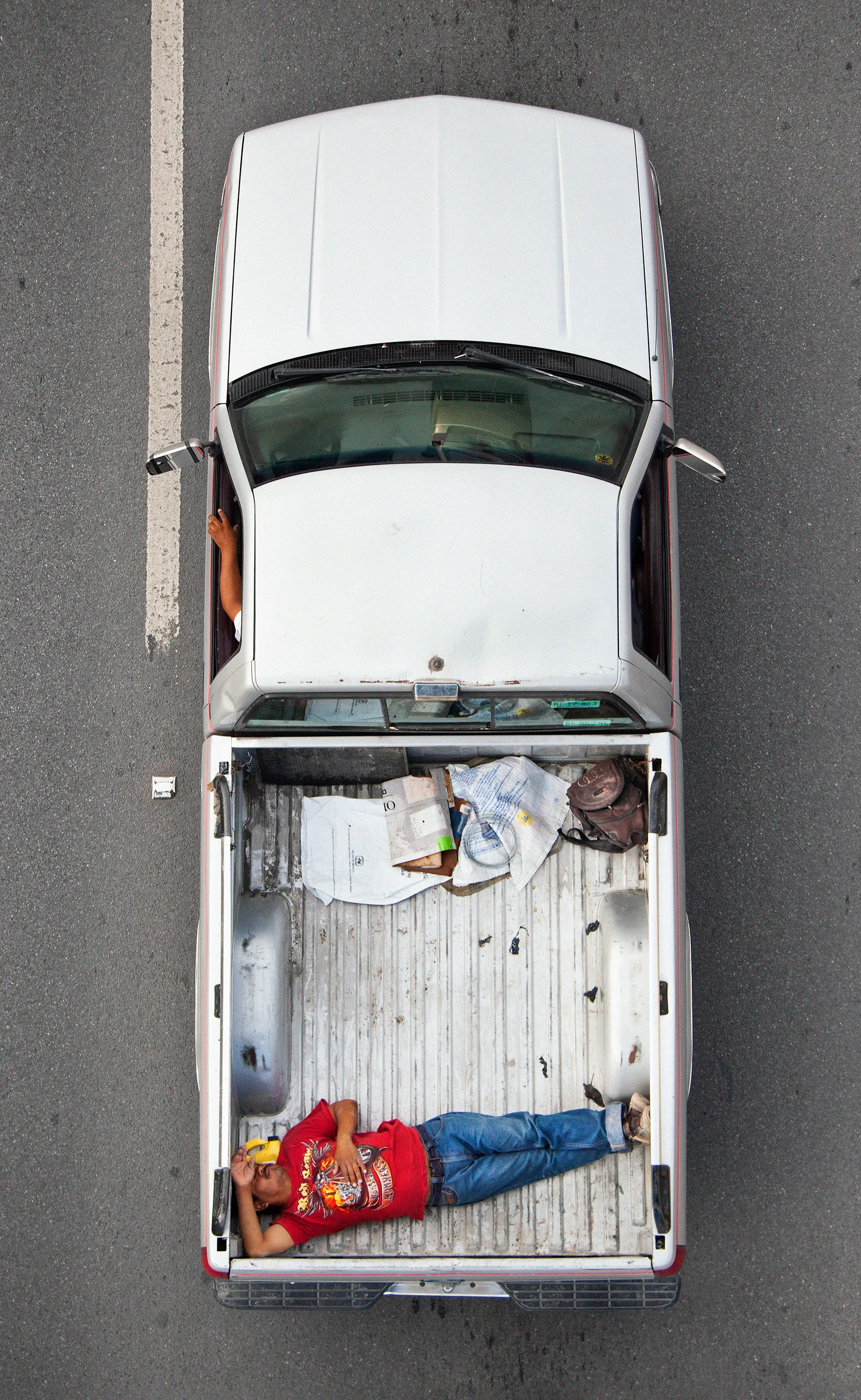 This photograph is part of my series, Carpoolers, which depicts laborers in México captured from an overpass, commuting between distant suburbs and urban centers. Like much of my work, this project comes from a desire to tell the story of the dramatic environmental, economic, and demographic changes playing out in my home city of Monterrey. This series has circulated the internet since 2011 and has been exhibited widely around the world. This piece is part of a collection of 50 works.