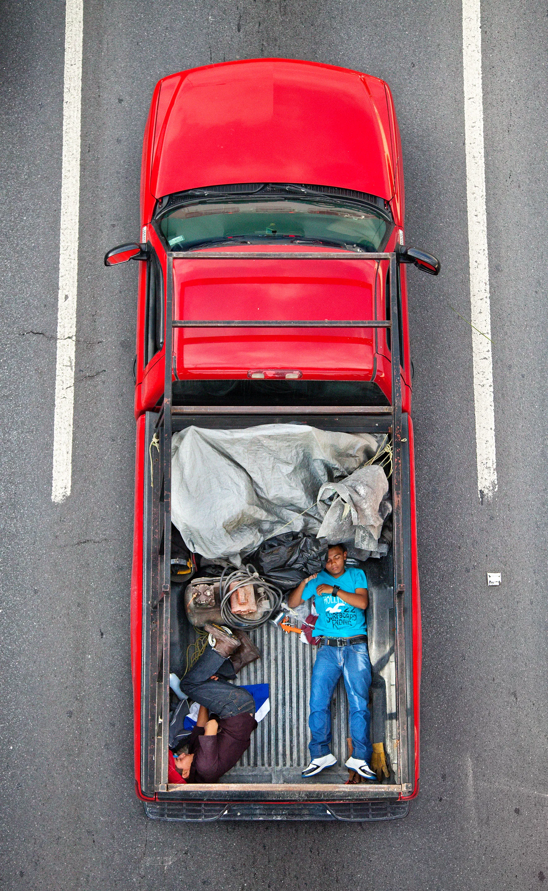 This photograph is part of my series, Carpoolers, which depicts laborers in México captured from an overpass, commuting between distant suburbs and urban centers. Like much of my work, this project comes from a desire to tell the story of the dramatic environmental, economic, and demographic changes playing out in my home city of Monterrey. This series has circulated the internet since 2011 and has been exhibited widely around the world. This piece is part of a collection of 50 works.