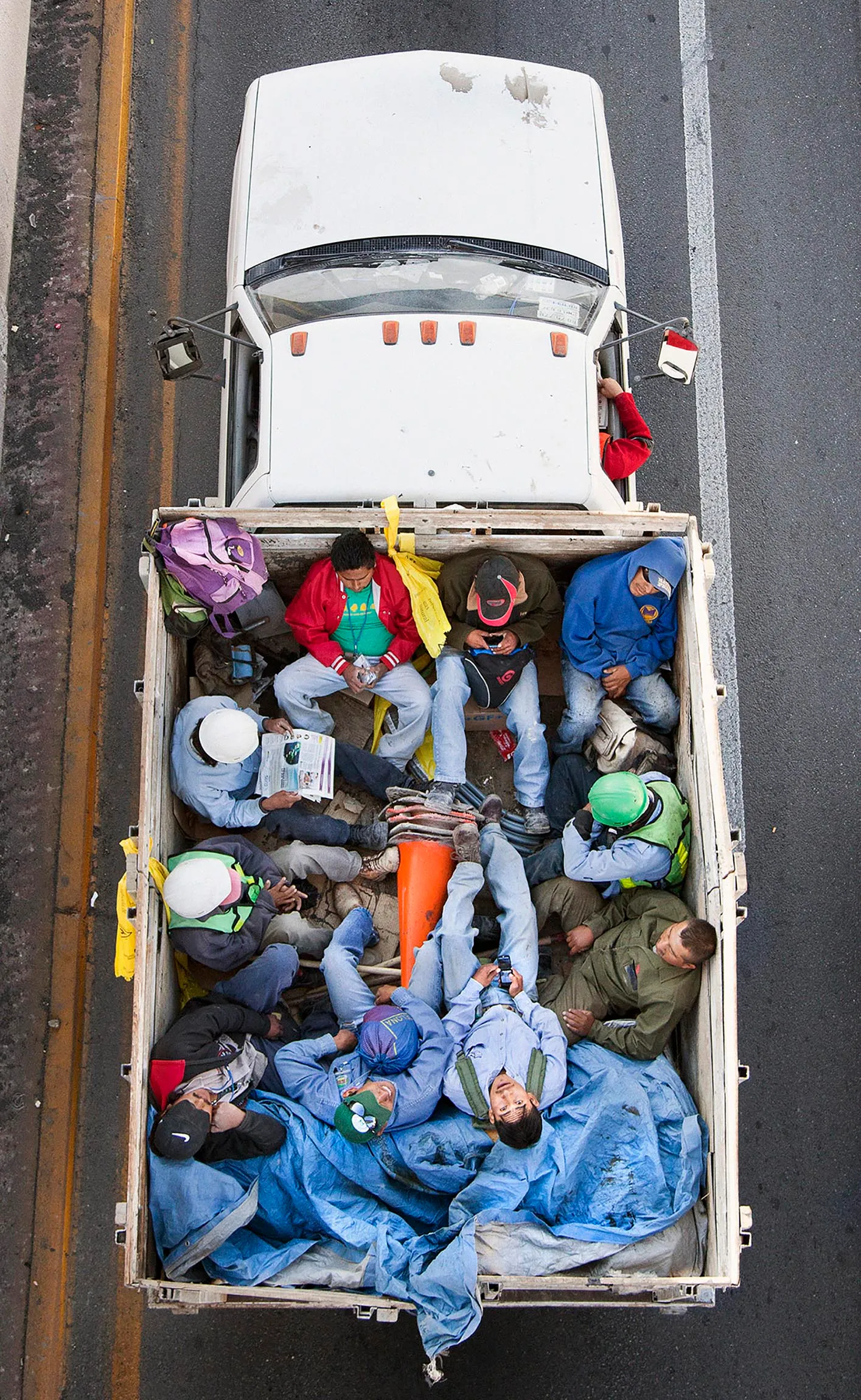 This photograph is part of my series, Carpoolers, which was inspired in part by my grandfather. A construction worker in México, he traveled this way for many years. These photographs were taken from an overpass and depict the many laborers who carpool between the distant suburbs and urban centers for work. This is a unique NFT of this photograph, which has been exhibited internationally and is in prominent museum collections around the world.