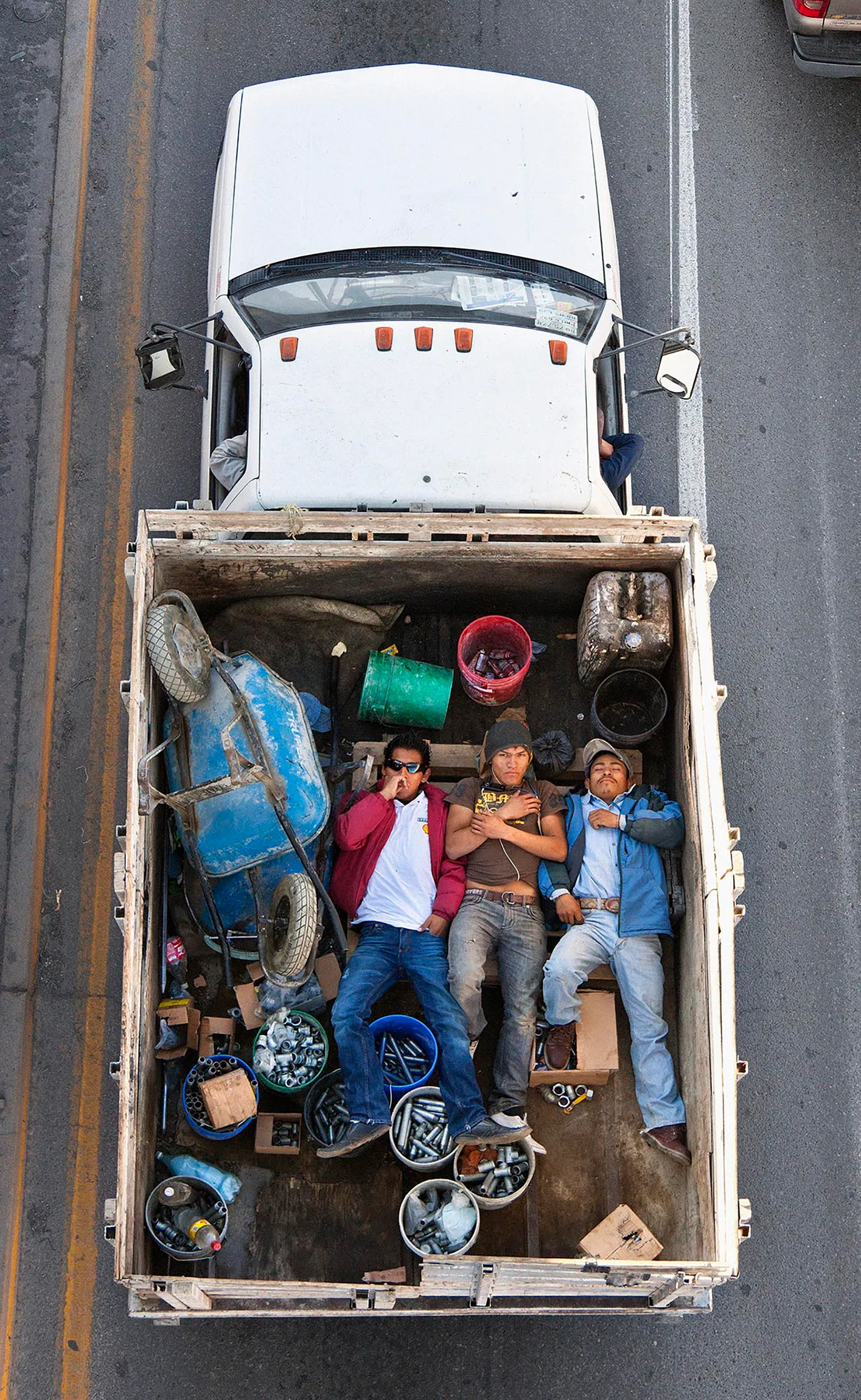 This photograph is part of my series, Carpoolers, which depicts laborers in México captured from an overpass, commuting between distant suburbs and urban centers. Like much of my work, this project comes from a desire to tell the story of the dramatic environmental, economic, and demographic changes playing out in my home city of Monterrey. This series has circulated the internet since 2011 and has been exhibited widely around the world.