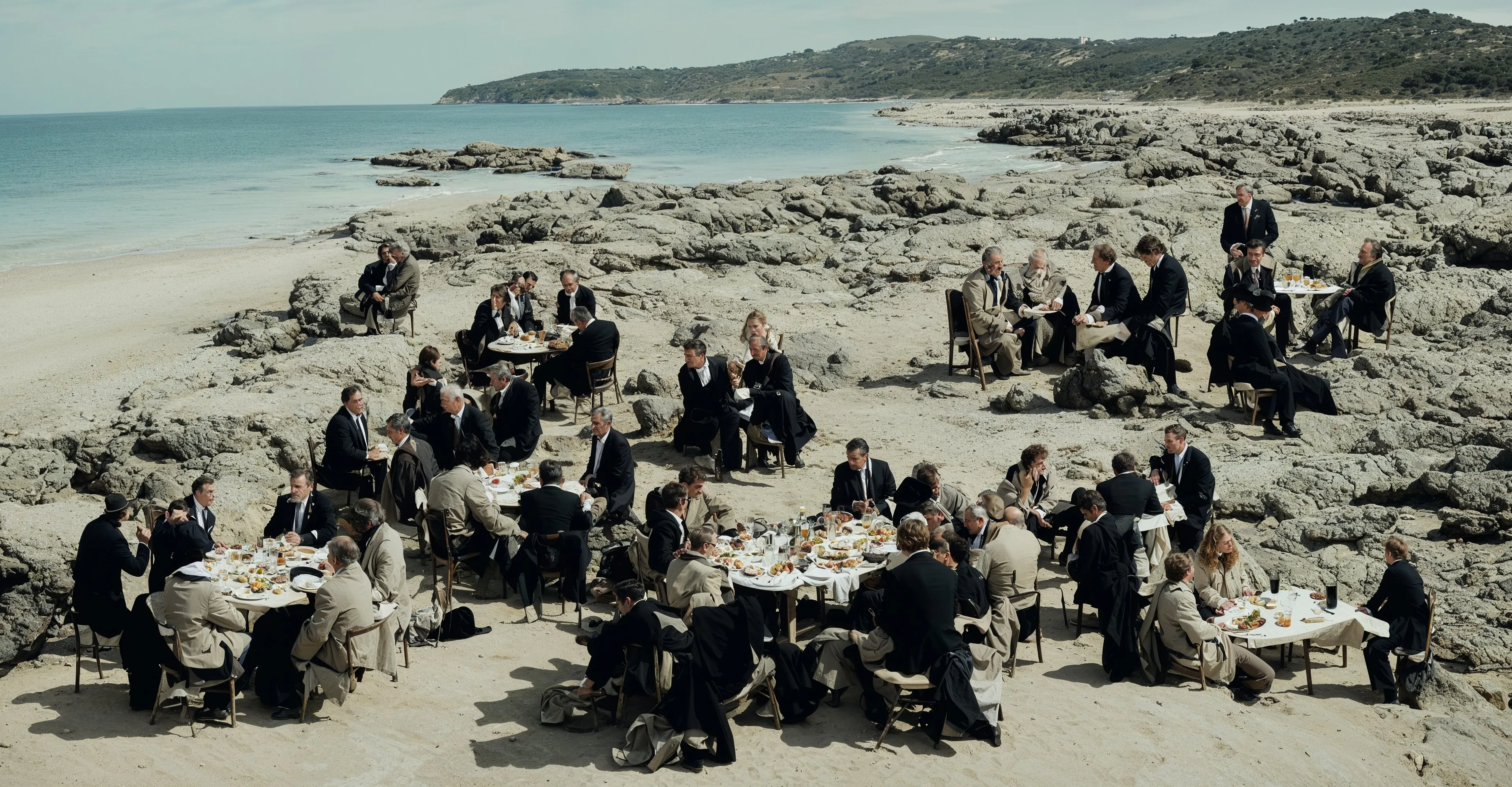 "The Banquet on the Shore," a compelling piece from "The Crossing" collection, depicts a gathering of individuals engaged in a communal meal along the rugged coast. The image is a study in contrasts: the formality of the diners' attire and the structured arrangement of the tables stand in stark opposition to the wild, untamed beauty of the natural shoreline. The juxtaposition suggests a narrative of civilization meeting the elemental forces of nature. The guests, immersed in conversation and dining, appear almost out of time, evoking a sense of the historical continuity of human social rituals. This photograph, with its rich textures and the expansive seascape, serves as a metaphor for life's journeys and the crossings we undertake. The shared meal becomes a symbol of the sustenance we seek—both physical and communal—as we navigate the passages of our lives.