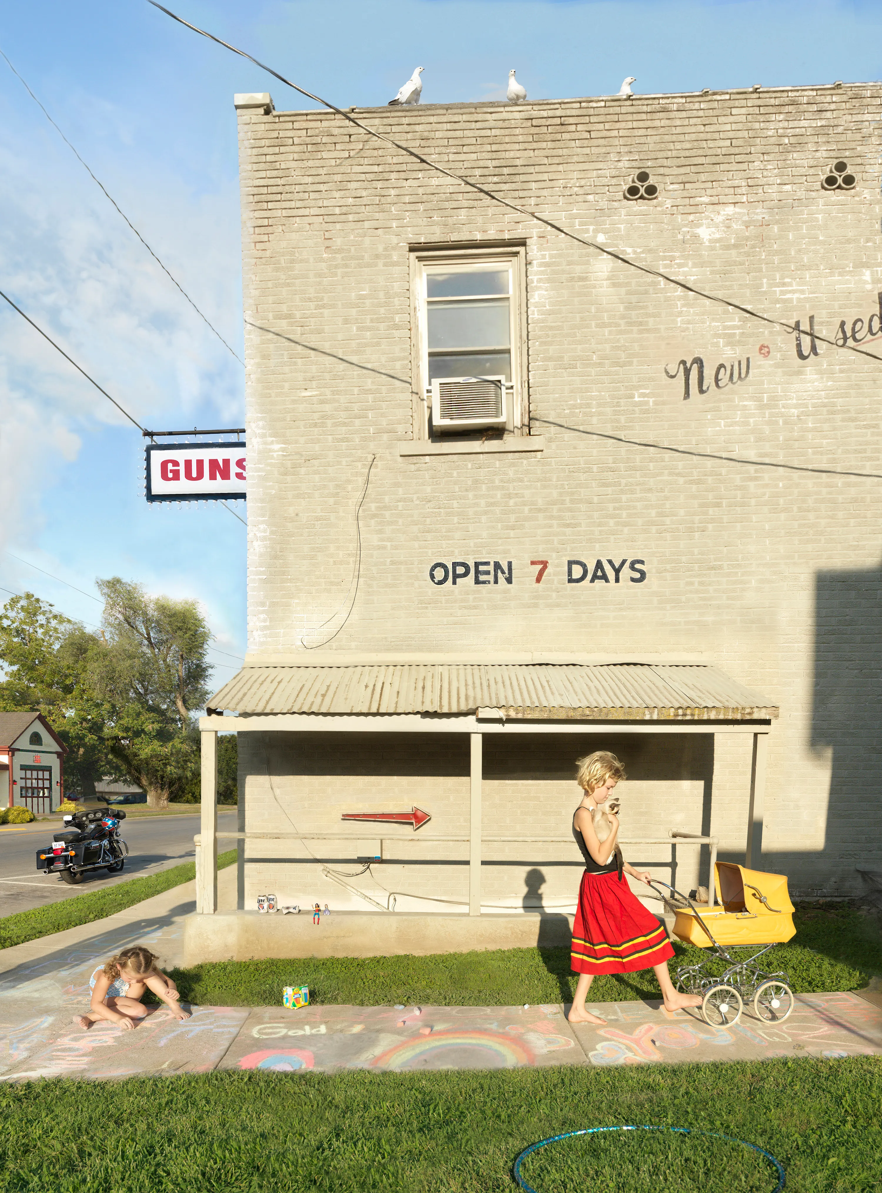 “I suppose I could make a work where the sun is shining, the mom is lying out in the grass, the kids are happy, and everything is perfect, but that wouldn’t interest me—and it wouldn’t be truthful. My aim is to create a more nuanced, subtly humorous and satirical portrait of the way we live today.” - Julie Blackmon

The playfully artful and chaotic elements present in the photographs of Julie Blackmon (American, b. 1966) are drawn from the everyday people and places of Blackmon’s daily routine in her hometown of Springfield, Missouri, which she describes as “a generic American town in the middle of the United States.” At first glance, the works may conjure backyard paradises of children at play; a closer look reveals children alone in backyards, garages, and neighborhoods, where the absence of adults suggests a looming potential for danger. The images brim with fantasy and subtle satire that capture a delicate balance between the darkness and charm of contemporary American life.

Blackmon carefully sets her scenes, but like film and theater
directors, she is in pursuit of unscripted moments that provoke,
disturb, and challenge the viewer. Some of the images reference
paintings by Dutch masters, French impressionists, and such modern painters as Hopper and Balthus, but they are updated with a satirical, penetrating eye and Blackmon’s belief that artful fiction can capture the truth more memorably than the truth itself.

#57