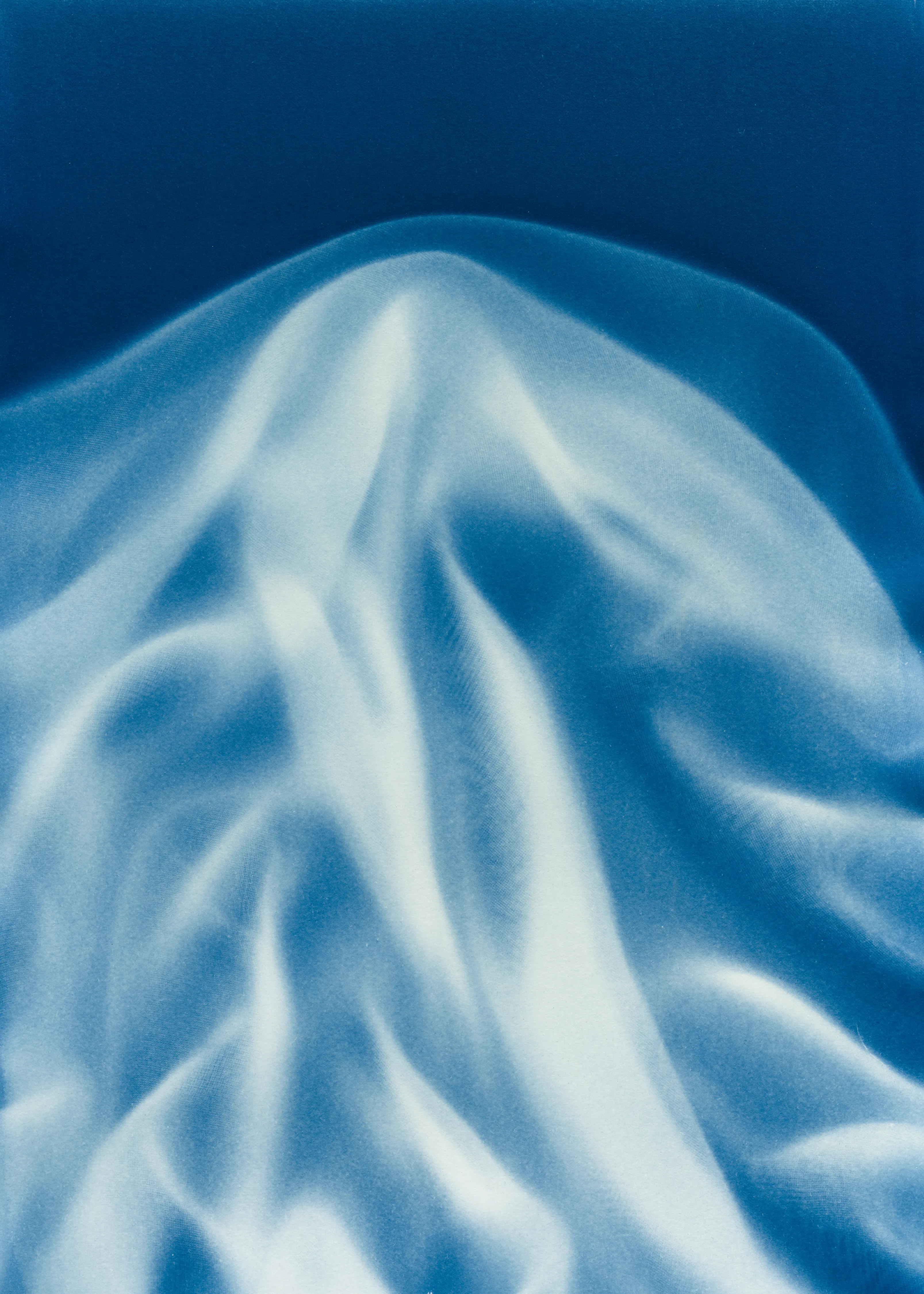 Beyond the Veil is simultaneously a melding of mediums as a means to sculpt with light, and an attempt to
capture the fabric of reality. I work with cyanotype, an alternative photography process that yields blue-
toned impressions when exposed to UV light. 
Cyanotype allows me to interact directly with light, one of the most subtle phenomena we experience day to day. Combined with sculpture, collage and drawing, the
cyanotype process is a powerful creative tool fueled by the sun. Working with light and shadow is to
become aware of how they describe our reality.

Created over the past eight months, this collection has been my safe haven from the world. A finger on the
pulse of something deeper than the chaotic rhythm of daily life, an album of captive sunlight and
experiences preserved in blue. The stillness of winter sunlight, silent rolling waves, a slow, even breath. I
hope you too can find solace here.