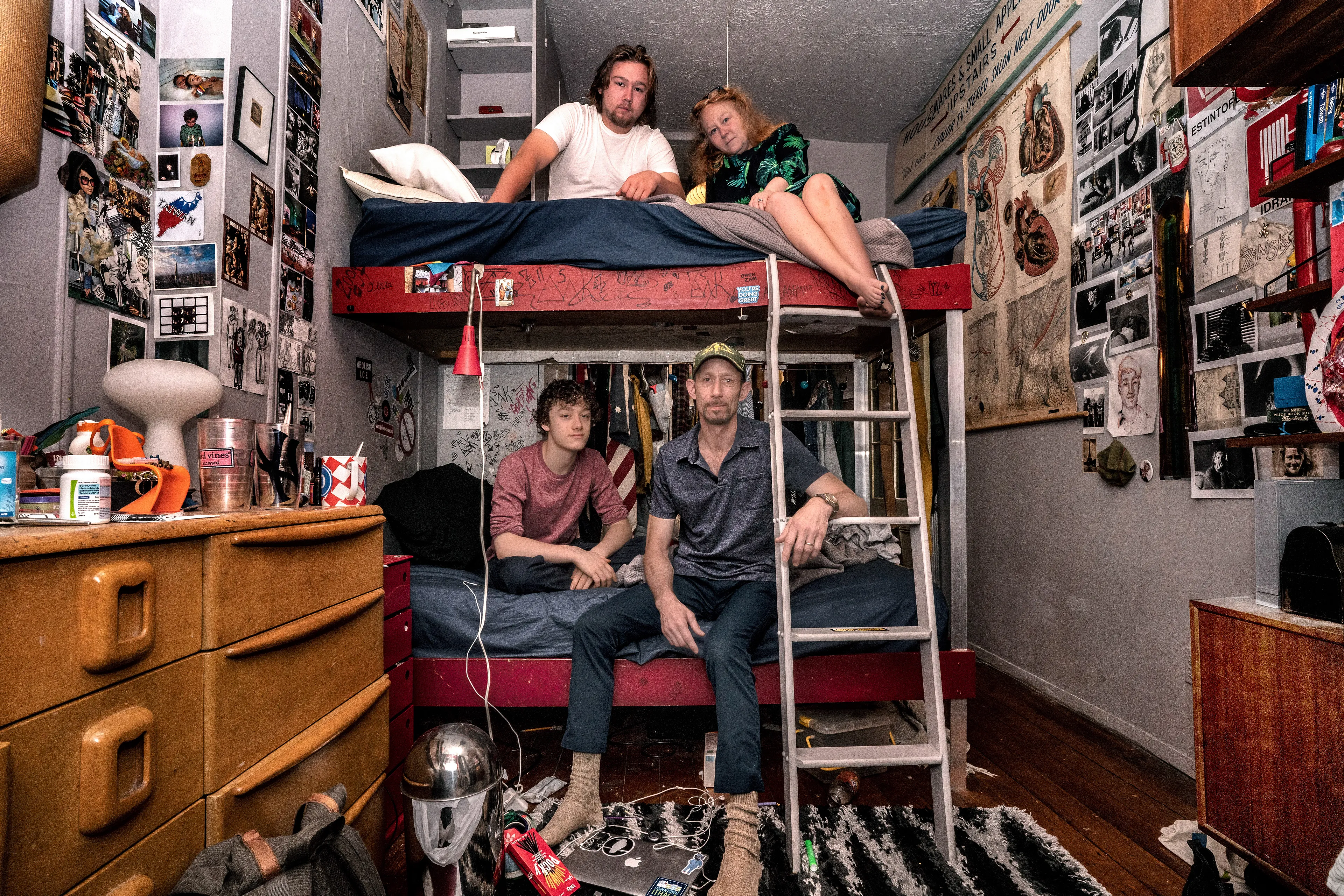 For the past 30 years, Sally Davies has been documenting the streets of Manhattan. She’s watched neighborhoods negotiate with gentrification, post-9/11 anxiety, economic uncertainty, and a steady stream of “if I can make it there, I’ll make it anywhere” optimism. Davies has taken memorable photographs of ordinary doorways, wet curbs and corners, the glow of bar-grill signs, bodegas, bakery windows, wheelchairs on rooftops, incoming weather, graffiti, and vintage cars. As she has said, “You either fall in love with moonlight on a garbage bag or you hate it and move along.”*

Davies started the New Yorkers by shifting from her usual view of the urban outdoors to the idea of chronicling the spaces and stories of the natives and transplants who give the city its particular vitality. 

In these portraits, you will meet waitresses, musicians, cab drivers, painters, teachers, shopkeepers, writers, designers, producers, parents, a gossip columnist, and a psychic to the stars, among others. They are singularly sensational, and they attest to multiple jobs, friendships, marriages, divorces, children, and pets. Young and old, straight and gay, casual and formal; they pose in cramped kitchens and elegant living rooms, laying on beds, sitting in bathtubs, surrounded by the surfaces and souvenirs of living. There is an abundance of brick, wood, leather, and metal, and collections of refrigerator magnets, religious and street art, books, Pez dispensers, vinyl records, and plants.

These photographs and texts speak to what all New Yorkers understand—to live in this city is to embrace struggle, sacrifice, love, and change. When I spoke with Davies over breakfast in February 2020, I asked her what this project reveals. She said, “This is the end of an era.” That comment has returned to me repeatedly. This book went to print during a pandemic that stopped the world as we knew it. We were in our homes for hours on end, adapting to new habits, while thinking and feeling deeply about where and how we live. These New York people were right on time.

by Stuart Horodner
*Sally Davies in Michael Ernest Sweet’s “Photographer Sally Davies Discusses Women Street Photographers,” HuffPost (December 15, 2015) 

Photographed with their sons Owen and Zachary at their home in the East Village on June 9, 2019.