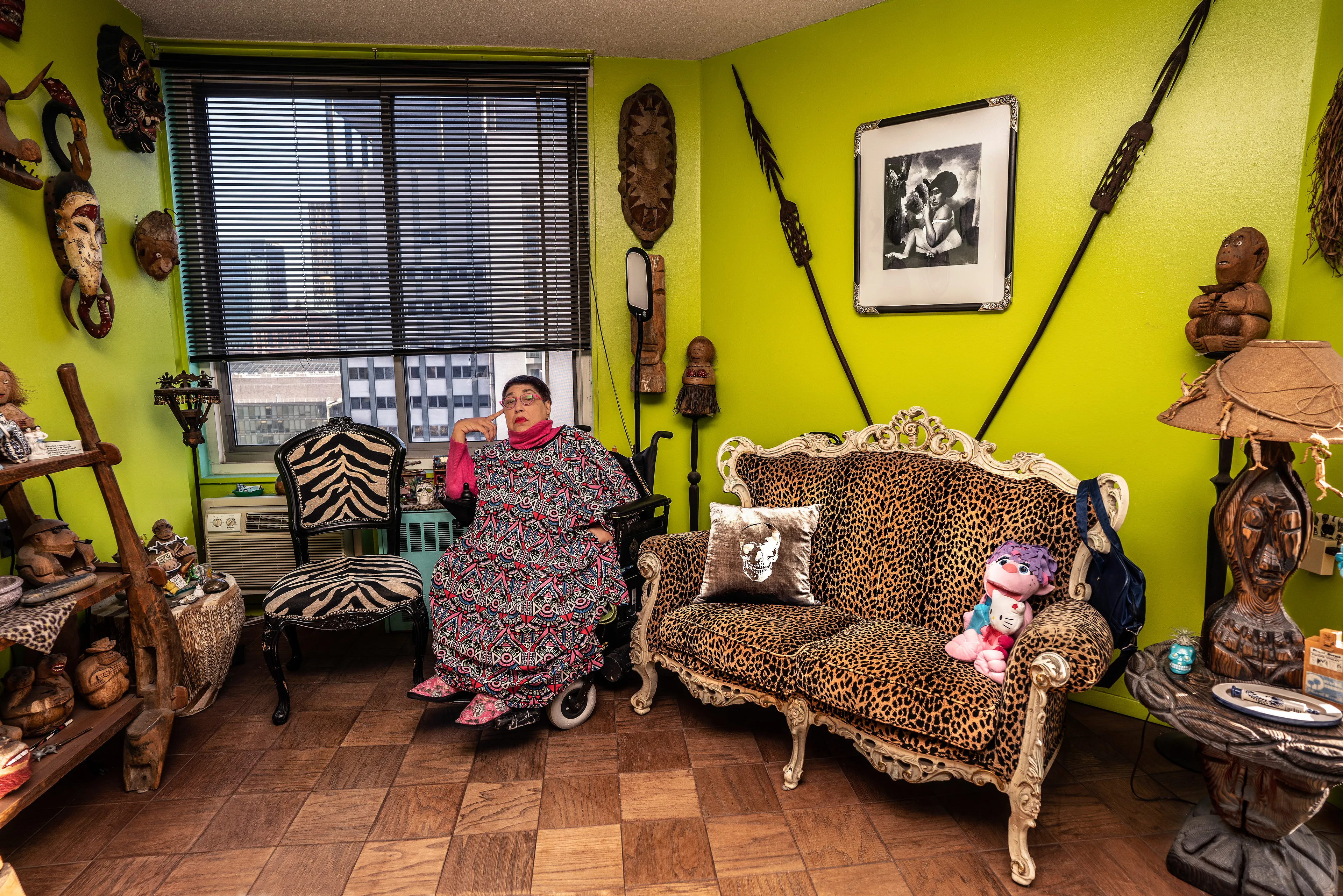 For the past 30 years, Sally Davies has been documenting the streets of Manhattan. She’s watched neighborhoods negotiate with gentrification, post-9/11 anxiety, economic uncertainty, and a steady stream of “if I can make it there, I’ll make it anywhere” optimism. Davies has taken memorable photographs of ordinary doorways, wet curbs and corners, the glow of bar-grill signs, bodegas, bakery windows, wheelchairs on rooftops, incoming weather, graffiti, and vintage cars. As she has said, “You either fall in love with moonlight on a garbage bag or you hate it and move along.”*

Davies started the New Yorkers by shifting from her usual view of the urban outdoors to the idea of chronicling the spaces and stories of the natives and transplants who give the city its particular vitality. 

In these portraits, you will meet waitresses, musicians, cab drivers, painters, teachers, shopkeepers, writers, designers, producers, parents, a gossip columnist, and a psychic to the stars, among others. They are singularly sensational, and they attest to multiple jobs, friendships, marriages, divorces, children, and pets. Young and old, straight and gay, casual and formal; they pose in cramped kitchens and elegant living rooms, laying on beds, sitting in bathtubs, surrounded by the surfaces and souvenirs of living. There is an abundance of brick, wood, leather, and metal, and collections of refrigerator magnets, religious and street art, books, Pez dispensers, vinyl records, and plants.

These photographs and texts speak to what all New Yorkers understand—to live in this city is to embrace struggle, sacrifice, love, and change. When I spoke with Davies over breakfast in February 2020, I asked her what this project reveals. She said, “This is the end of an era.” That comment has returned to me repeatedly. This book went to print during a pandemic that stopped the world as we knew it. We were in our homes for hours on end, adapting to new habits, while thinking and feeling deeply about where and how we live. These New York people were right on time.

by Stuart Horodner
*Sally Davies in Michael Ernest Sweet’s “Photographer Sally Davies Discusses Women Street Photographers,” HuffPost (December 15, 2015) 

Photographed at her home in downtown Manhattan on November 21, 2019.