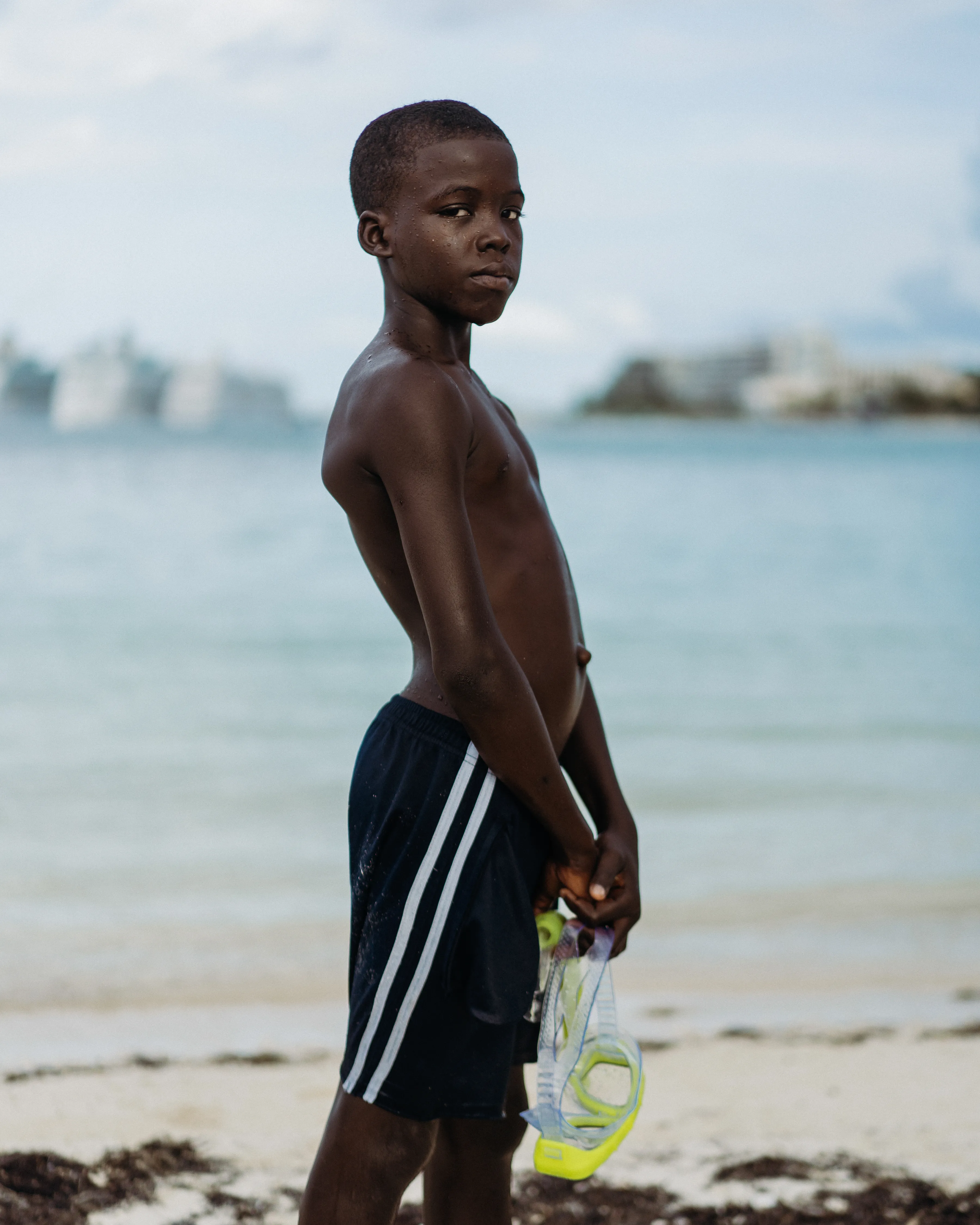 Melissa Alcena is a Nassau-based Bahamian portrait and documentary photographer. Her work often focuses on shifting the settler-colonial narrative of the Caribbean, and specifically The Bahamas. Alcena flips the script by directly engaging with Bahamians, putting them front and centre, showing them and her country as complex, sophisticated, and diverse. Her strong sense of colour, bright light, and deep shadow are  purely homegrown, yet unexpected and nuanced. Reaching past surface appearances framed by the colonial gaze, Alcena reveals the true nature of her sitters and the nation.