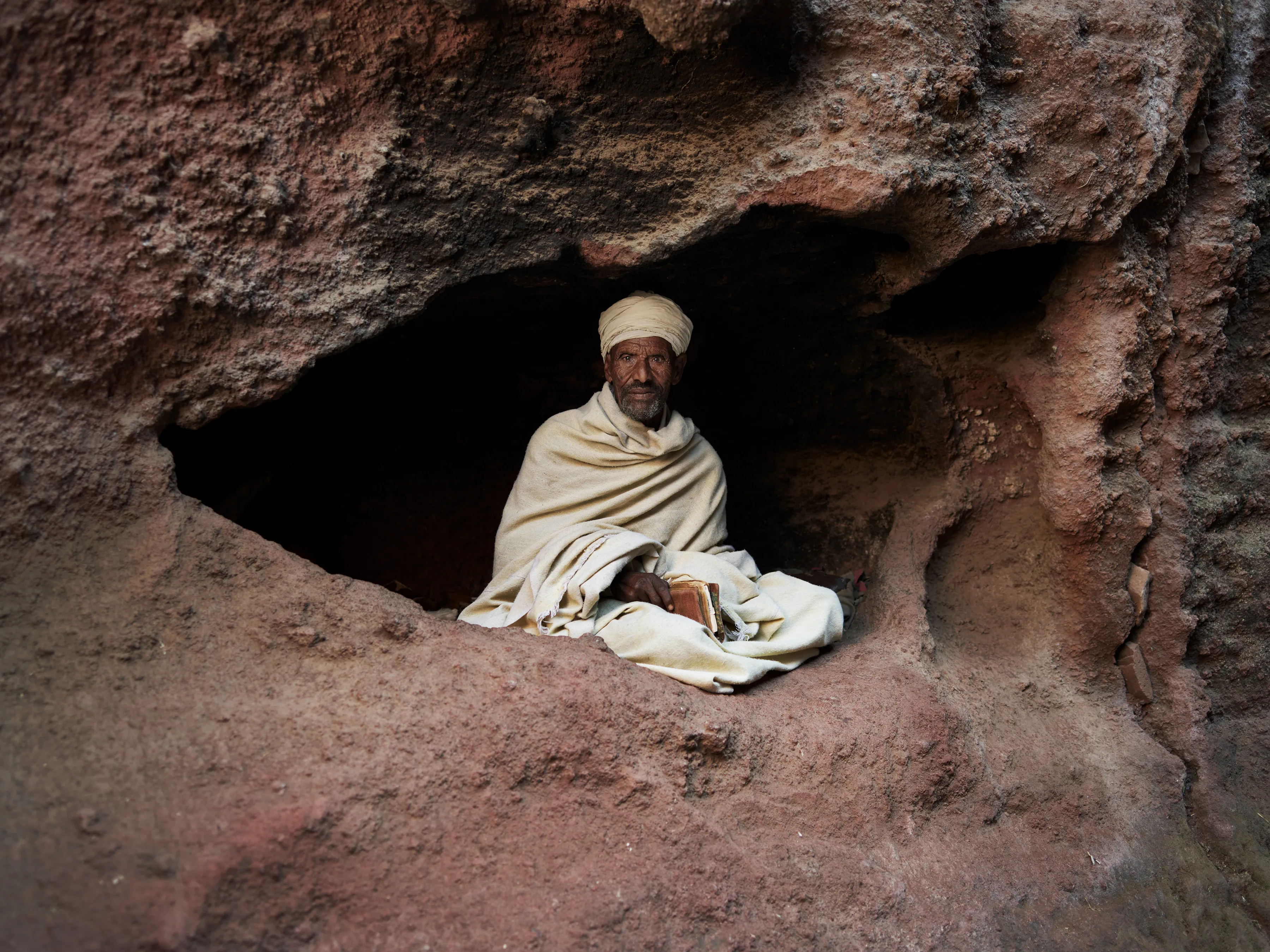 My life will forever be intertwined with Ethiopia. In my teenage days, this country is where I first found my vision as a photographer. Later, Ethiopia would be where I found my home and my soul mate. ETHIOPIA is a monolithic collection of my images captured over the course of thirteen years. It is an ode to every region of the country and a celebration of all the unique peoples found within. These seemingly disconnected cultural threads are woven together in a cohesive visual style in order to truly see Ethiopia— which itself is the sum of all the diverse lands and theproud people who inhabit it.

The dignified vision found in the portraits is not to obscure other searing
realities within Ethiopia, such as the wealth inequality and traumatic conflict
spread across the country. It is to highlight the prestige I have always
recognized here. This collection is about the timeless and pure things that
have withstood the politics of the day, and to challenge the way the outside
world can perceive this country. This is my tribute to the enduring Ethiopia.

Meregeta took a break from studying the bible to be photographed. Bilbala, Amhara Region, Ethiopia.

Location - Ethiopia Medium - digital capture Series - Ethiopia
