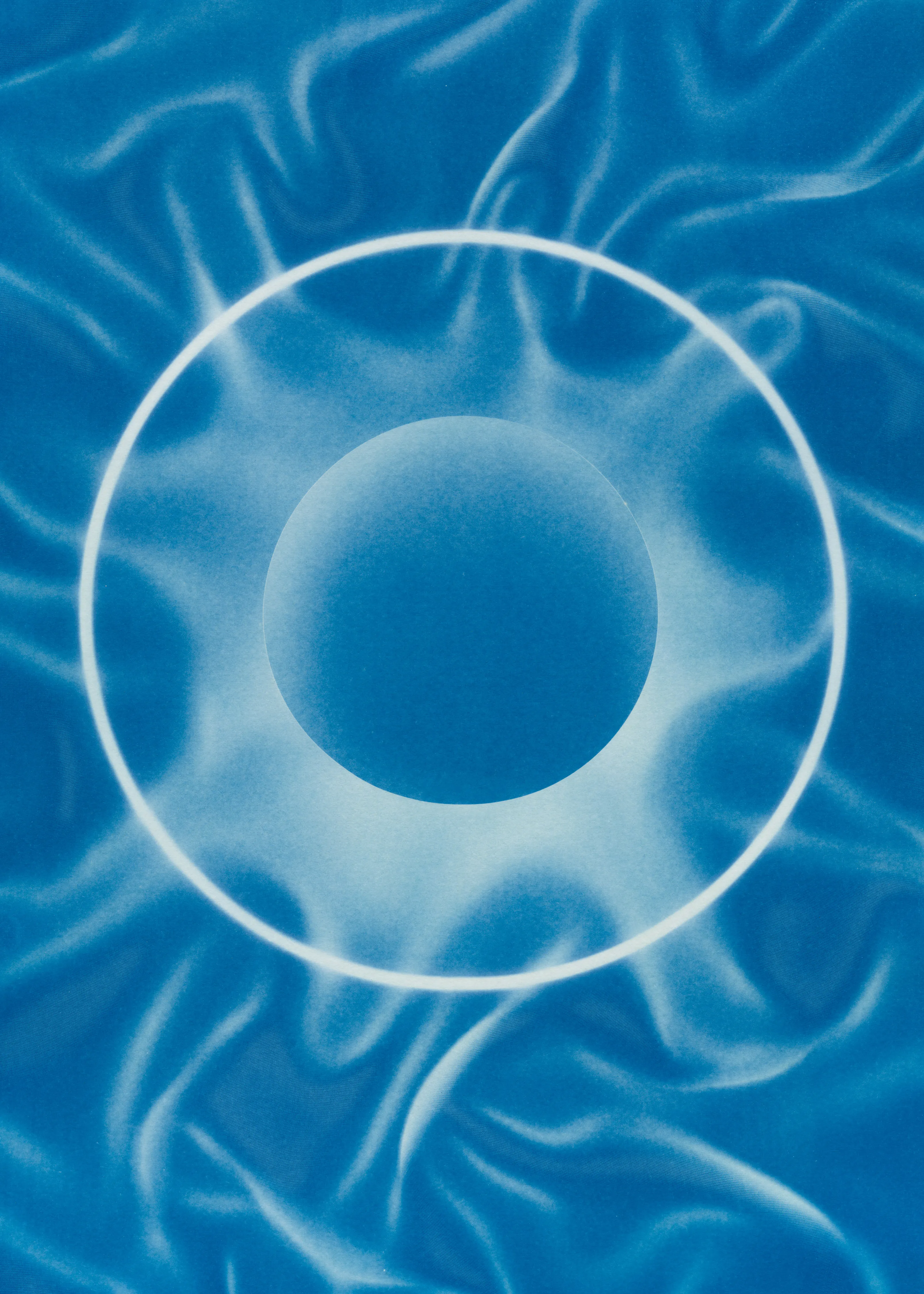 Beyond the Veil is simultaneously a melding of mediums as a means to sculpt with light, and an attempt to
capture the fabric of reality. I work with cyanotype, an alternative photography process that yields blue-
toned impressions when exposed to UV light. 
Cyanotype allows me to interact directly with light, one of the most subtle phenomena we experience day to day. Combined with sculpture, collage and drawing, the
cyanotype process is a powerful creative tool fueled by the sun. Working with light and shadow is to
become aware of how they describe our reality.

Created over the past eight months, this collection has been my safe haven from the world. A finger on the
pulse of something deeper than the chaotic rhythm of daily life, an album of captive sunlight and
experiences preserved in blue. The stillness of winter sunlight, silent rolling waves, a slow, even breath. I
hope you too can find solace here.