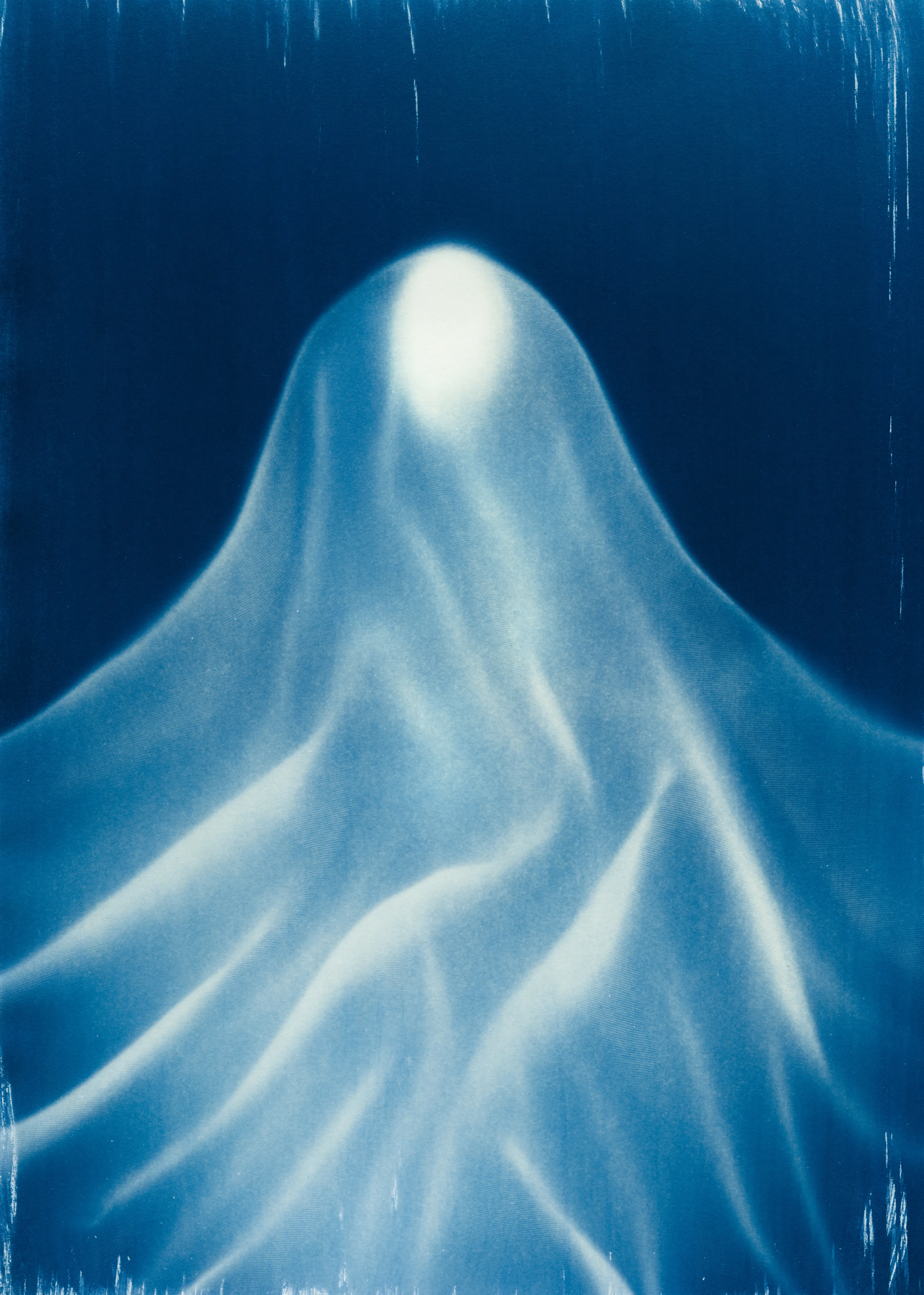 Beyond the Veil is simultaneously a melding of mediums as a means to sculpt with light, and an attempt to
capture the fabric of reality. I work with cyanotype, an alternative photography process that yields blue-
toned impressions when exposed to UV light. 
Cyanotype allows me to interact directly with light, one of the most subtle phenomena we experience day to day. Combined with sculpture, collage and drawing, the
cyanotype process is a powerful creative tool fueled by the sun. Working with light and shadow is to
become aware of how they describe our reality.

Created over the past eight months, this collection has been my safe haven from the world. A finger on the
pulse of something deeper than the chaotic rhythm of daily life, an album of captive sunlight and
experiences preserved in blue. The stillness of winter sunlight, silent rolling waves, a slow, even breath. I
hope you too can find solace here.