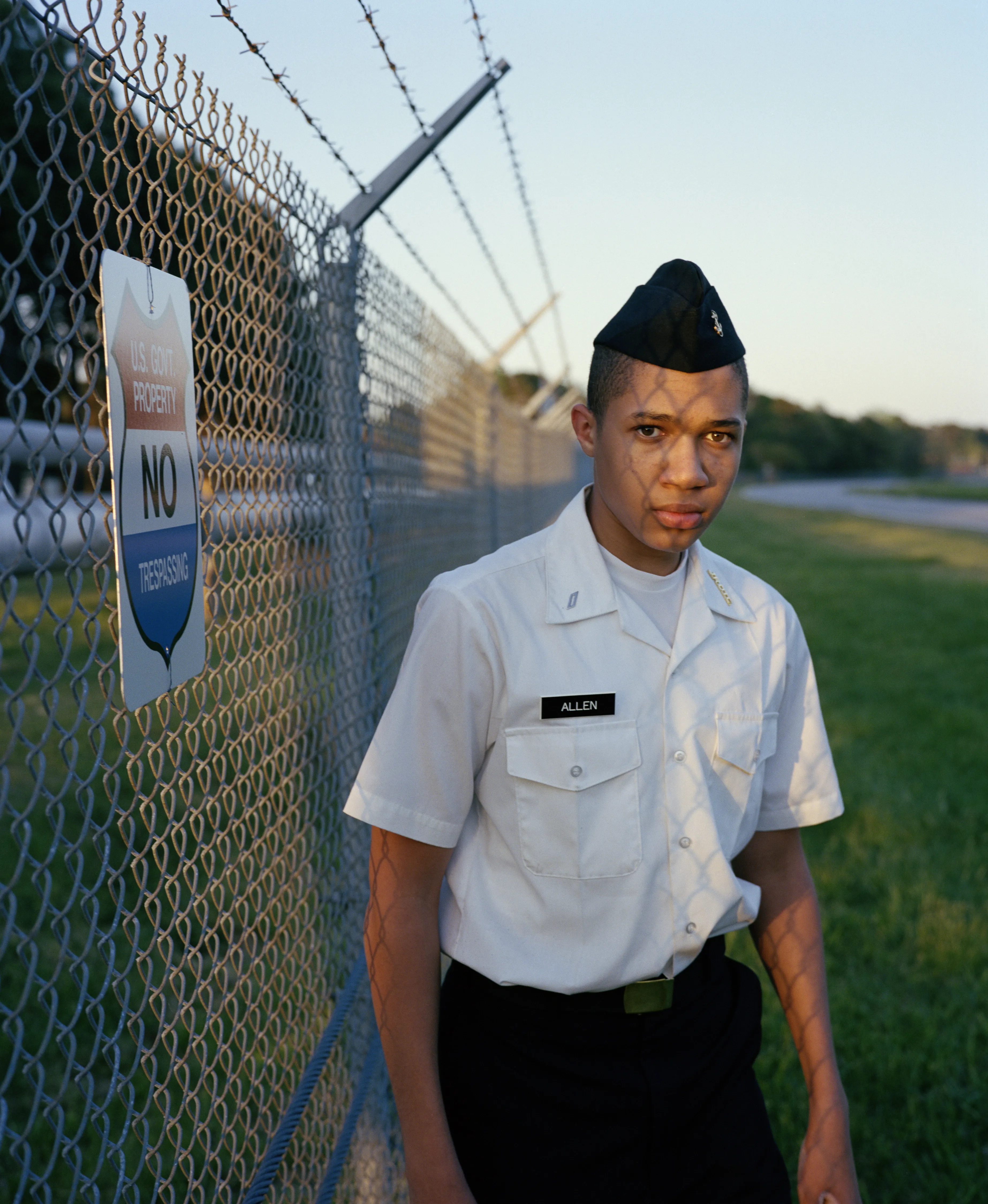 Right before I made the first image of Sharrod, when he went to his bedroom to change, his mother turned to me and said, “Whenever he puts on his uniform, I no longer see my son.”

In the winter of 2008 I met Sharrod, who was in his first year of high school and had recently enrolled in National Junior Reserve Officer’s Training Corps (NJROTC), a military preparatory program offered in high schools nationwide. After explaining my connection to the military and that I was an alum of the same high school that both Sharrod and his mother attended, I asked if I might photograph Sharrod from his freshman to senior year (2008-2012). They both agreed and over the course of the next four years, Sharrod played out his military fantasies for my camera. Sharrod also shared with me the photographs he was making with his cell phone and notebook doodles of weapon construction. These private images and examinations rub up against, color, and compliment the medium format images I’ve made providing the viewer a fuller image of Sharrod’s journey.

Over the course of making the images and video installations for "I slowly watched him disappear," I wondered about the process within which the military body is formed both literally but also psychologically, visually, and emotionally. What is the process of indoctrination and how does the heavy flow of military marketing messages — specifically in military towns— foreclose possibilities for a life beyond the uniform? Furthermore, can one photographically locate the transition from civilian to member of the military unit? 

"I slowly watched him disappear" is the first part of a multimedia “essay” including photographs, video installations, nonfiction films, curatorial projects, and texts which organize my meditations on the fantasy, construction, and deconstruction of the military body and its effects on the broader culture.  