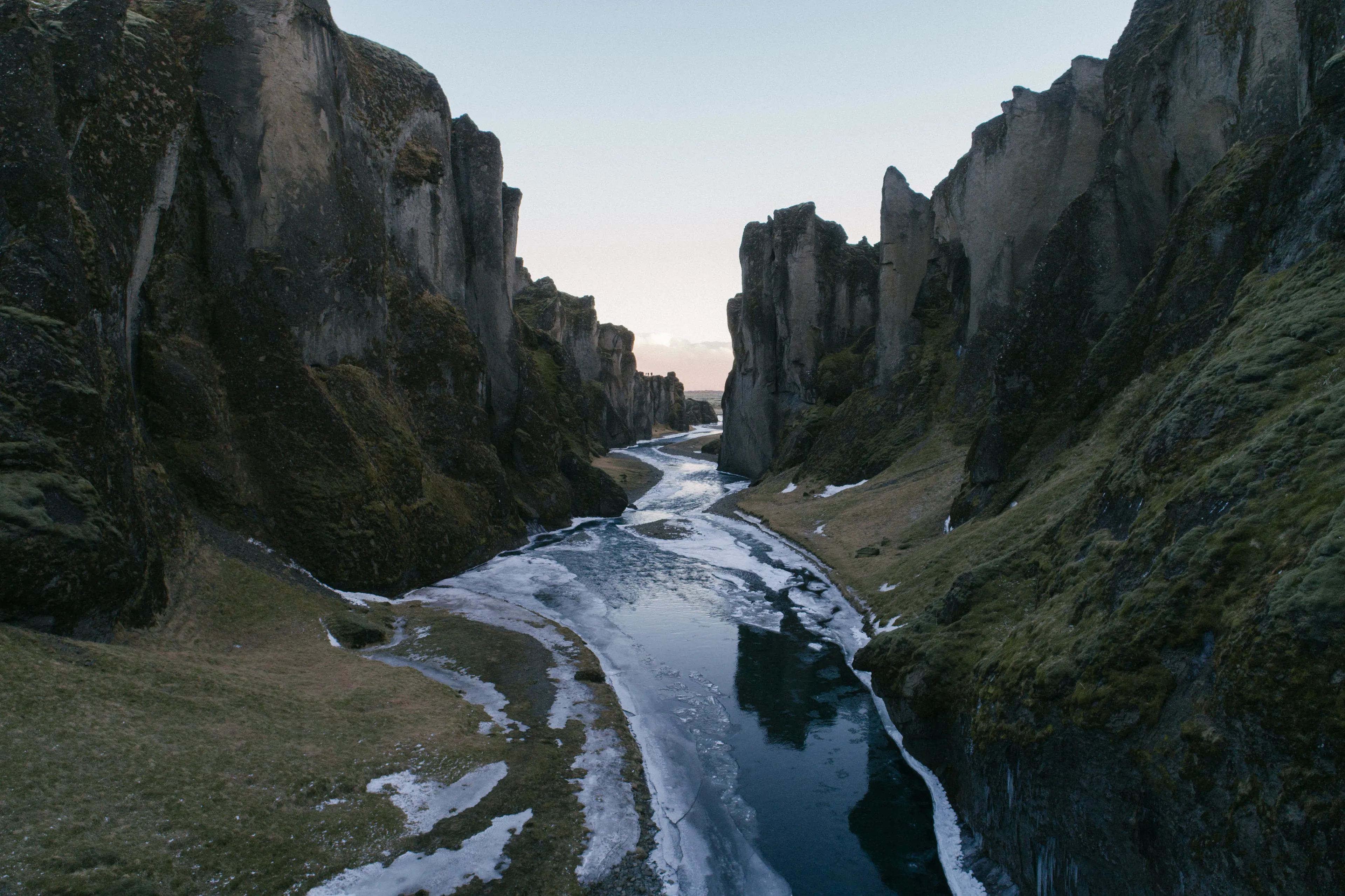 Towering icebergs, doomed expeditions in tall ships, desolate landscapes with naught but howling wind– this was the vast Arctic from the paintings of European explorers in the 19th century. That romance carries on in the 21st century, even as the ice vanishes and increasing numbers of people experience the North in person.

When the future has its way with the North, it will leave a radically altered land. The sea ice and its denizens will have vanished.  Contemporary Inuit will be living vastly different lifestyles than that of their ancestors. Future generations will look back to remember a land little understood by outsiders. Will the imaginations of foreigners paint the sole history of an Arctic with ice and snow? What are the memories of the 3 million Greenlandic Kalallit, Alaskan Iñupiat, and European Samí who call the Arctic their home?

Despite my ancestry as a Native Siberian, I experience the Arctic both as an insider and an outsider. My years there have left me with a vision of a multi-chromatic Far North. This is a land blued with ancient ice, deepened by blood, and radiant under the northern lights. My Arctic nostalgia is not for sailing ships, but for skinboats. My strongest memories are intimate ones– the smell of fermented seal oil, the sting of ice crystals on snowmobile rides, and the background din of howling Greenlandic huskies.

A future North awaits– not cold and unchanging, but living, dying and being reborn. Everyday memories of the Arctic will pass forward as they always have, kept by its Indigenous peoples and hidden in plain sight.

Frozen waterfalls and young ice collect on a river running through Fjaðrárgljúfur canyon, a 100m deep fissure through southern Iceland.