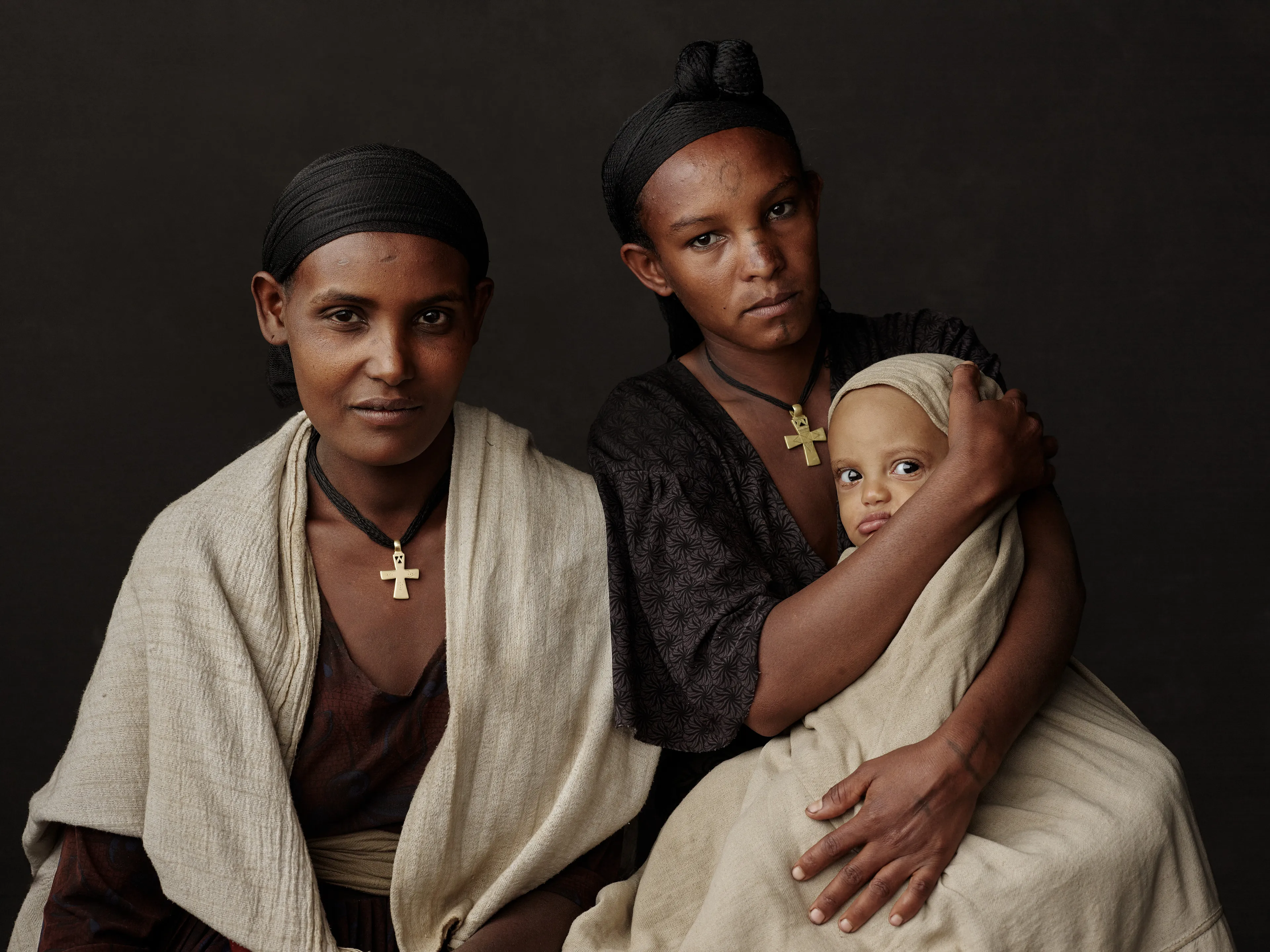 Joey L. returns to Quantum with Ethiopia - Portraits: a collection directly linked to his genesis drop during Season 1. For every environmental image from Joey’s first drop, there is a portrait companion.

“For years, we dragged our nomadic studio tent across almost every region of Ethiopia. In our tent, everyone was equal. We captured pure magic. Every kind of person entered and had their portrait taken. The tent was our little fantasy world. It was the Ethiopia that we dreamed of, even when the reality outside of it was sometimes stricken with searing pain. Each portrait was a tribute to a distinct region of the country. Disconnected cultural threads were woven together in a cohesive visual style in order to truly see Ethiopia— which itself is a modern nation state, but is also the sum of all the diverse people who inhabit it.”

Joey’s portraits alternating on red and black backdrops are the visual backbone of my forthcoming book “Ethiopia” (Insight Editions, January 2023), which compiles 13 years of work.

The tent itself is a metal frame modified with diffusion material made out of netela fabric, which is a hand-spun cotton perfected by Dorze craftspeople. Every portrait is created with natural light molded from the tent itself and photographed on location.

Amhara, Bilbala, 
Amhara Region, Ethiopia  
January 2021