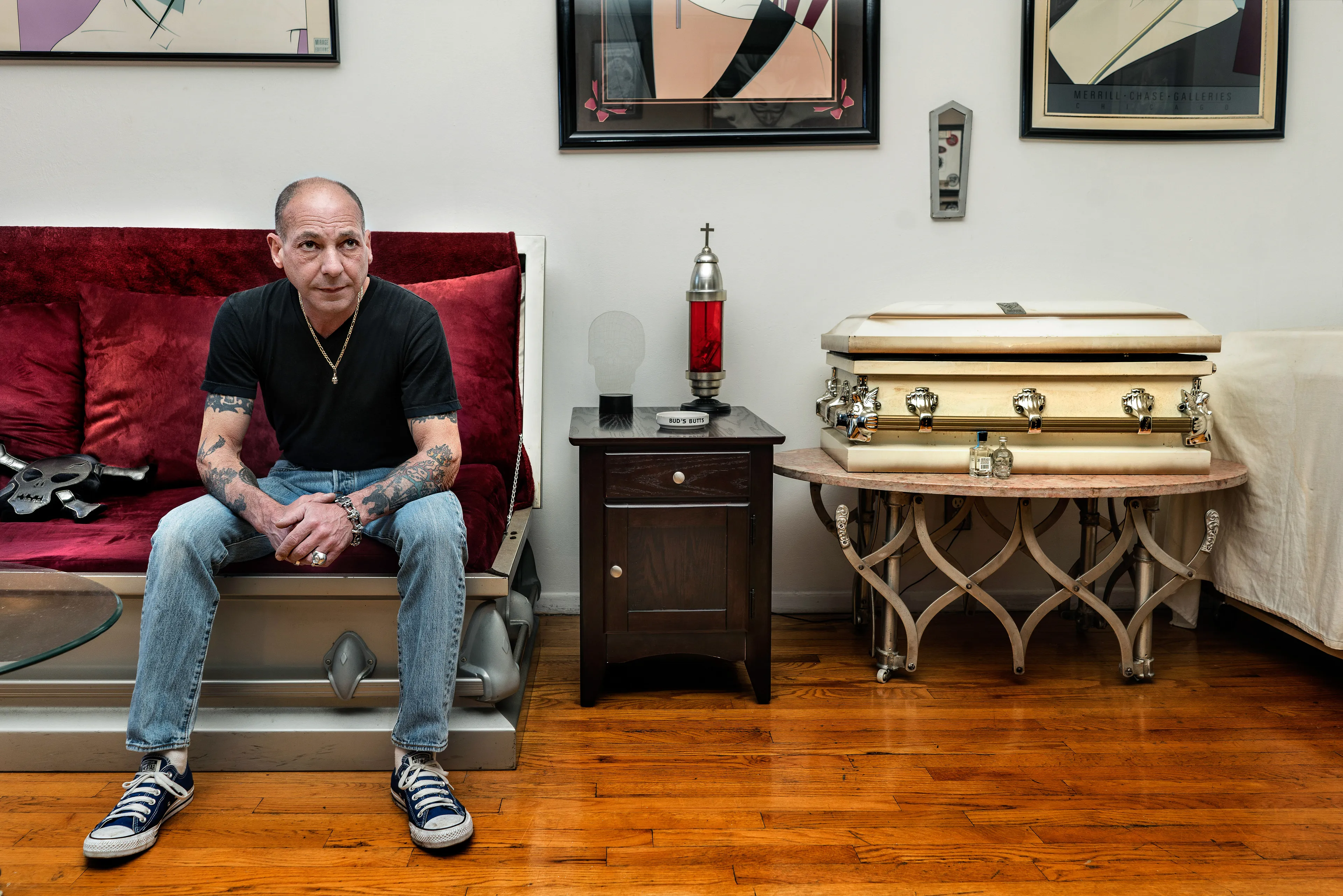 For the past 30 years, Sally Davies has been documenting the streets of Manhattan. She’s watched neighborhoods negotiate with gentrification, post-9/11 anxiety, economic uncertainty, and a steady stream of “if I can make it there, I’ll make it anywhere” optimism. Davies has taken memorable photographs of ordinary doorways, wet curbs and corners, the glow of bar-grill signs, bodegas, bakery windows, wheelchairs on rooftops, incoming weather, graffiti, and vintage cars. As she has said, “You either fall in love with moonlight on a garbage bag or you hate it and move along.”*

Davies started the New Yorkers by shifting from her usual view of the urban outdoors to the idea of chronicling the spaces and stories of the natives and transplants who give the city its particular vitality. 

In these portraits, you will meet waitresses, musicians, cab drivers, painters, teachers, shopkeepers, writers, designers, producers, parents, a gossip columnist, and a psychic to the stars, among others. They are singularly sensational, and they attest to multiple jobs, friendships, marriages, divorces, children, and pets. Young and old, straight and gay, casual and formal; they pose in cramped kitchens and elegant living rooms, laying on beds, sitting in bathtubs, surrounded by the surfaces and souvenirs of living. There is an abundance of brick, wood, leather, and metal, and collections of refrigerator magnets, religious and street art, books, Pez dispensers, vinyl records, and plants.

These photographs and texts speak to what all New Yorkers understand—to live in this city is to embrace struggle, sacrifice, love, and change. When I spoke with Davies over breakfast in February 2020, I asked her what this project reveals. She said, “This is the end of an era.” That comment has returned to me repeatedly. This book went to print during a pandemic that stopped the world as we knew it. We were in our homes for hours on end, adapting to new habits, while thinking and feeling deeply about where and how we live. These New York people were right on time.

by Stuart Horodner
*Sally Davies in Michael Ernest Sweet’s “Photographer Sally Davies Discusses Women Street Photographers,” HuffPost (December 15, 2015) 

Photographed at his apartment in the East Village on April 24, 2019.