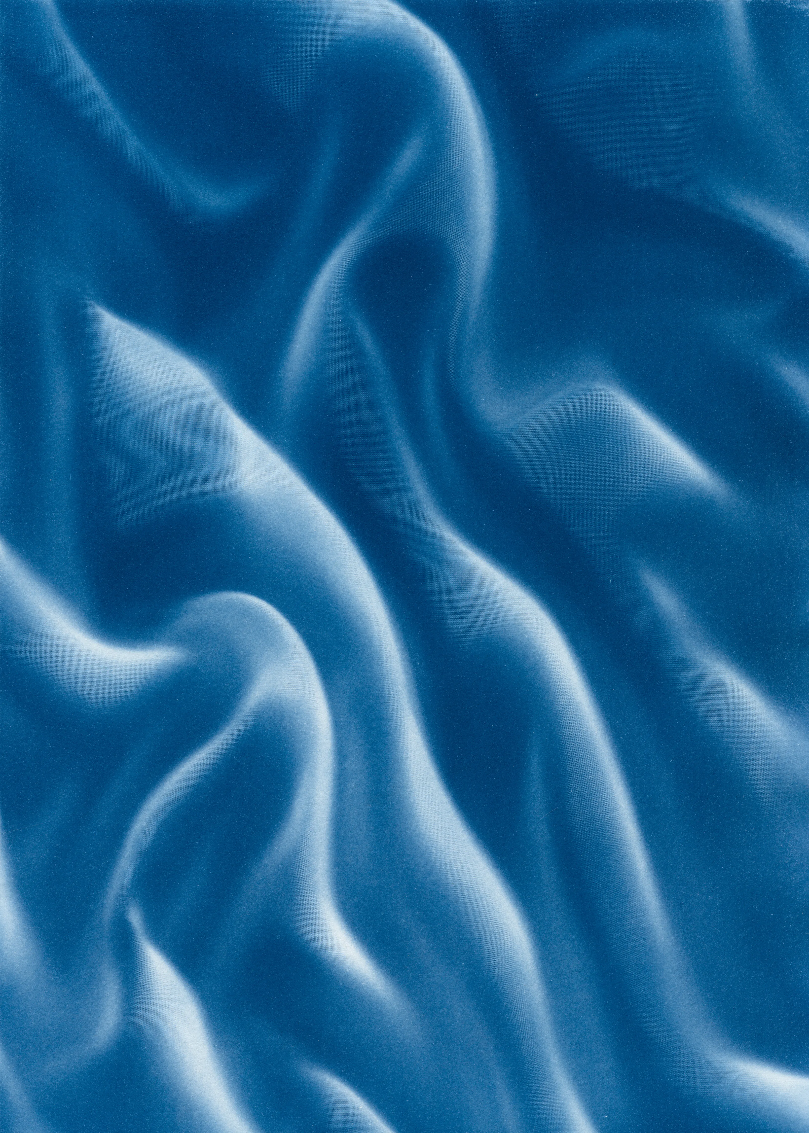 Beyond the Veil is simultaneously a melding of mediums as a means to sculpt with light, and an attempt to
capture the fabric of reality. I work with cyanotype, an alternative photography process that yields blue-
toned impressions when exposed to UV light. 
Cyanotype allows me to interact directly with light, one of the most subtle phenomena we experience day to day. Combined with sculpture, collage and drawing, the
cyanotype process is a powerful creative tool fueled by the sun. Working with light and shadow is to
become aware of how they describe our reality.

Created over the past eight months, this collection has been my safe haven from the world. A finger on the
pulse of something deeper than the chaotic rhythm of daily life, an album of captive sunlight and
experiences preserved in blue. The stillness of winter sunlight, silent rolling waves, a slow, even breath. I
hope you too can find solace here.