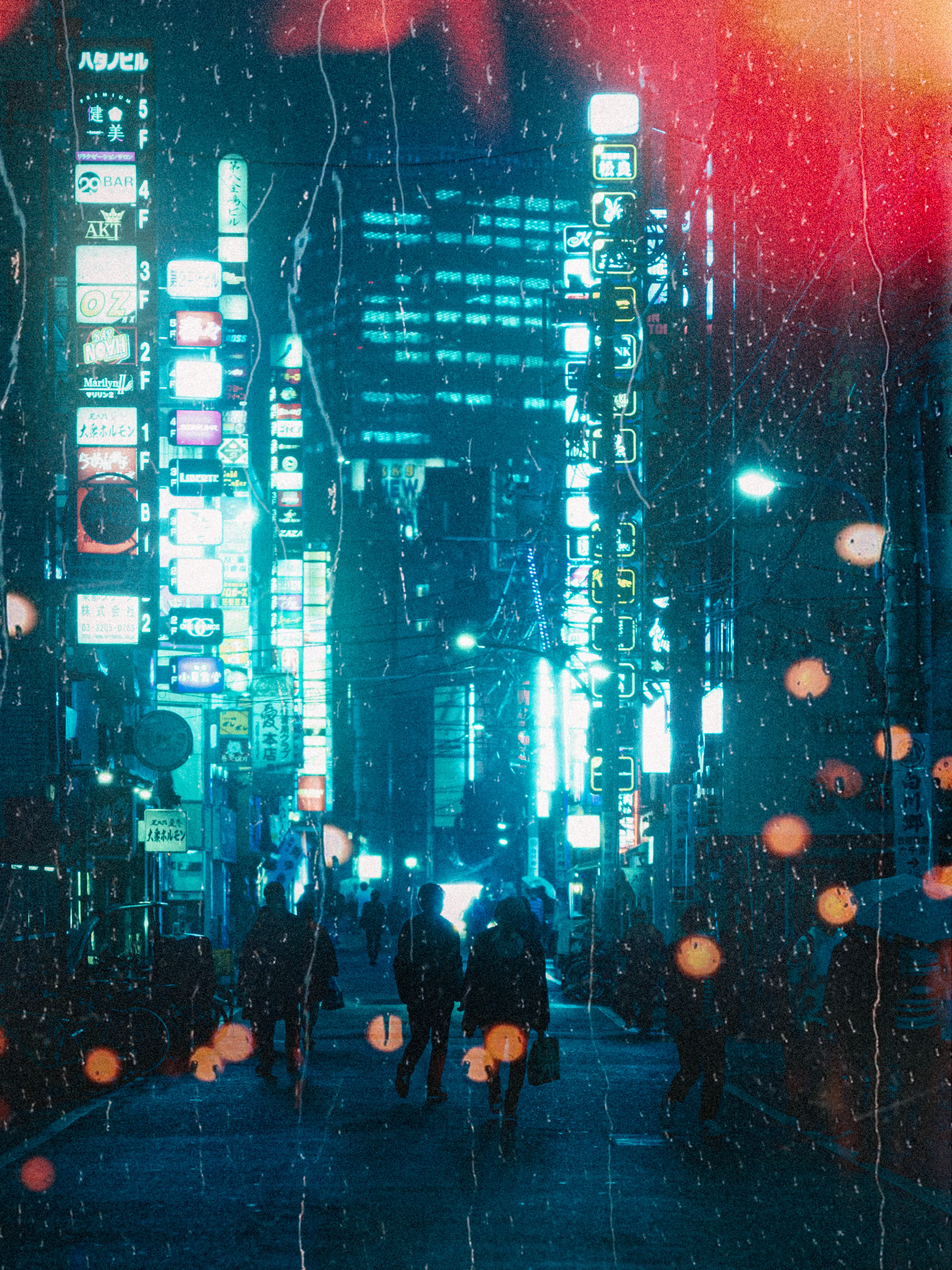 In Shinjuku's embrace, as raindrops descend,
Neon whispers weave, a city to transcend.
Glistening streets adorned in liquid light,
A dance with the rain, a Tokyo night's rite.

Umbrellas unfurl, like blossoms in the mist,
Reflecting neon hues, in every twist.
The rhythm of droplets, a soft serenade,
Shinjuku's heartbeat in the cascade.

Silhouettes sway 'neath an umbrella's shield,
Secrets shared in the rain, forever concealed.
Umbrella-lit alleys, where memories bloom,
In the quiet of rain, a city finds its room.

Neon signs flicker, painting stories untold,
In the heart of the city, mysteries unfold.
Rain-kissed pavements, a shimmering stage,
Shinjuku's allure, with each raindrop engaged.

Through the misty veil, where dreams align,
Shinjuku's neon nights, forever entwine.
In the rain's soft cadence, a melody of grace,
A Tokyo love story, in this watery embrace.

By: Ilan Derech
Location: Tokyo, Japan
Shot on: Leica M7 & KODAK Portra 800
Year: 2023