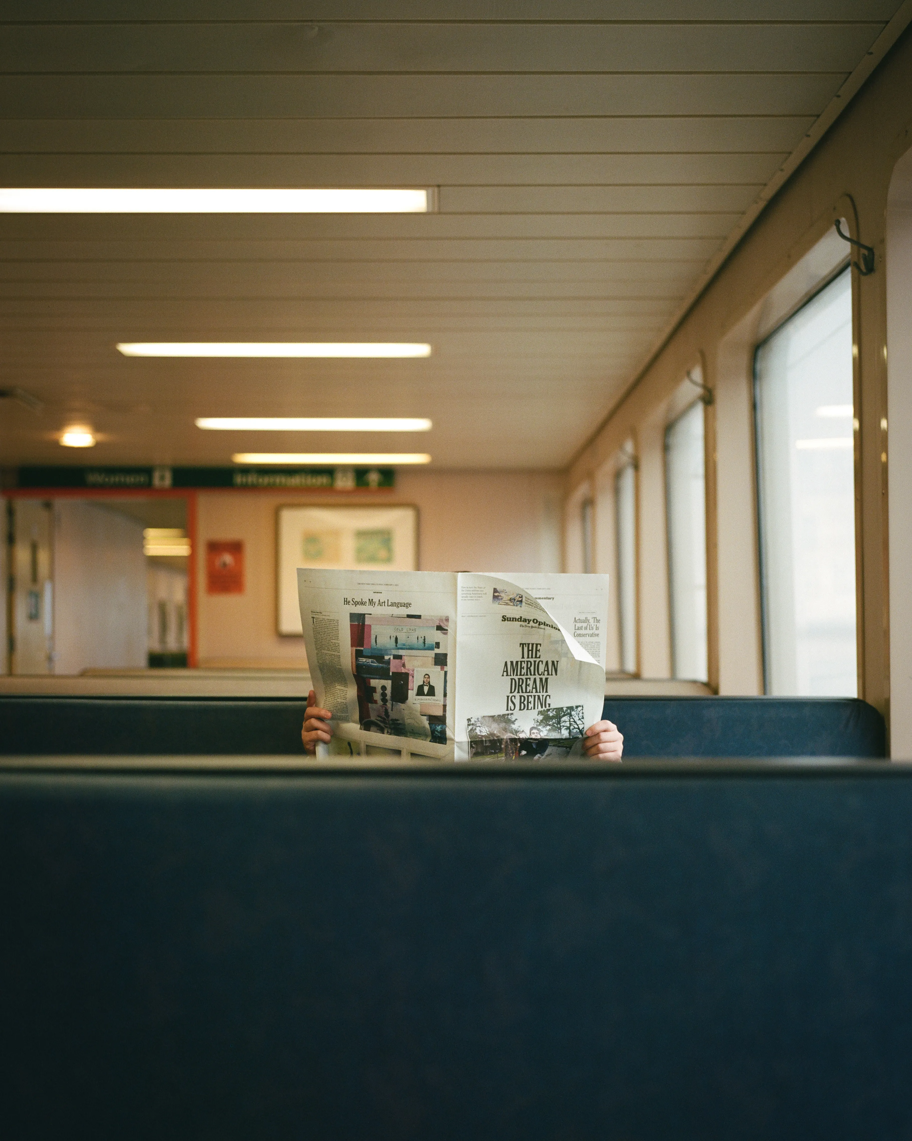 "Lost in the headlines, a solitary soul finds solace, embracing the serenity of a Seattle day, as the ferry sails through time and tides."