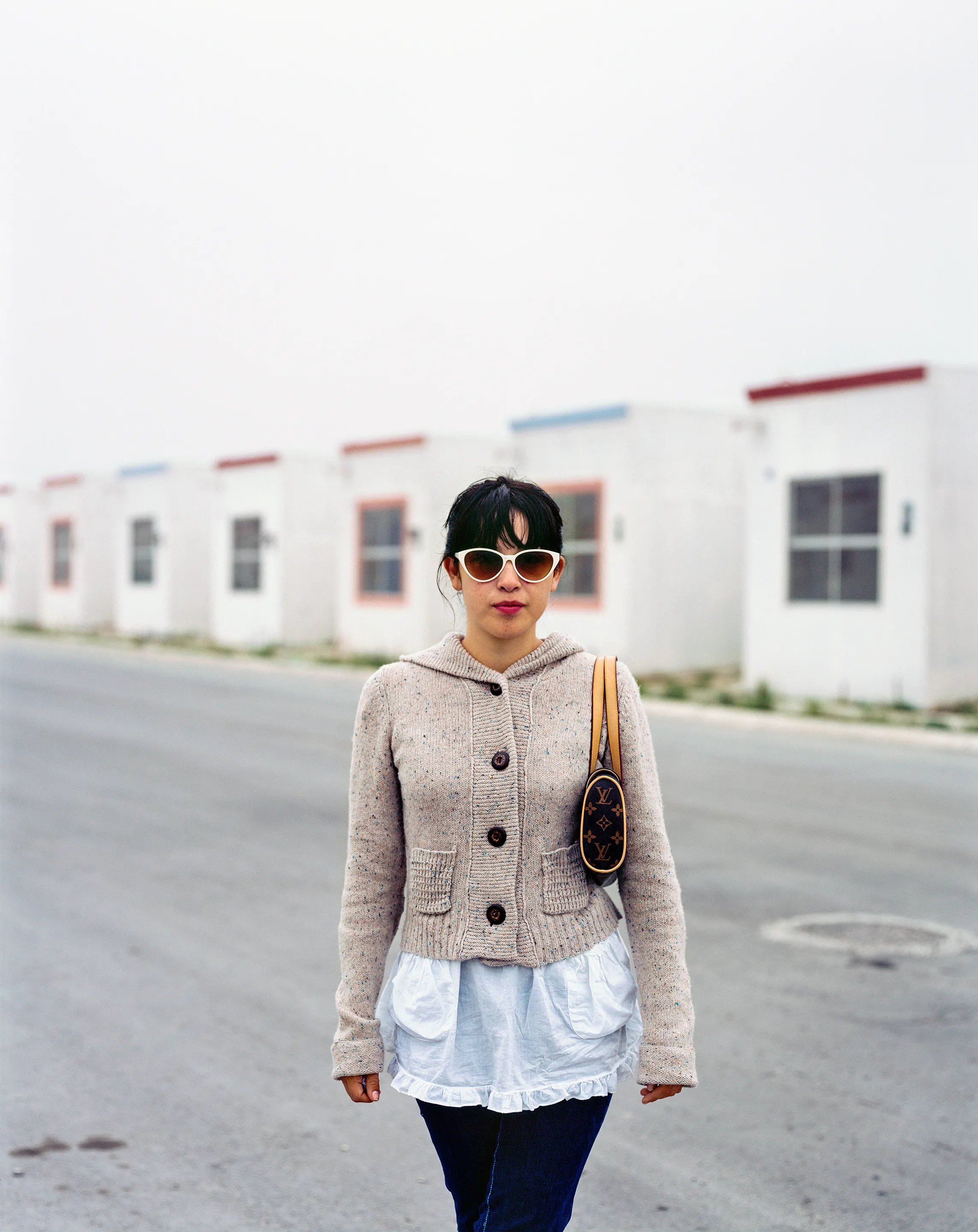 Girl Coming Home to Suburb in Juarez from a Night Out in the City. Juárez, Nuevo León, Mexico, 2005-2010. This image is part of a 5-year project called Suburbia Mexicana. During the first 10 years of the 21st Century, Mexico put forward a housing project that resulted in the construction of hundreds of thousands of homes around my hometown of Monterrey. These are the people who dared to dream to own a new home. I encountered them in their new suburbs and asked them to be part of the representation of a changing landscape we were both living through at that time.  All images were done with a large format 4x5 film camera.