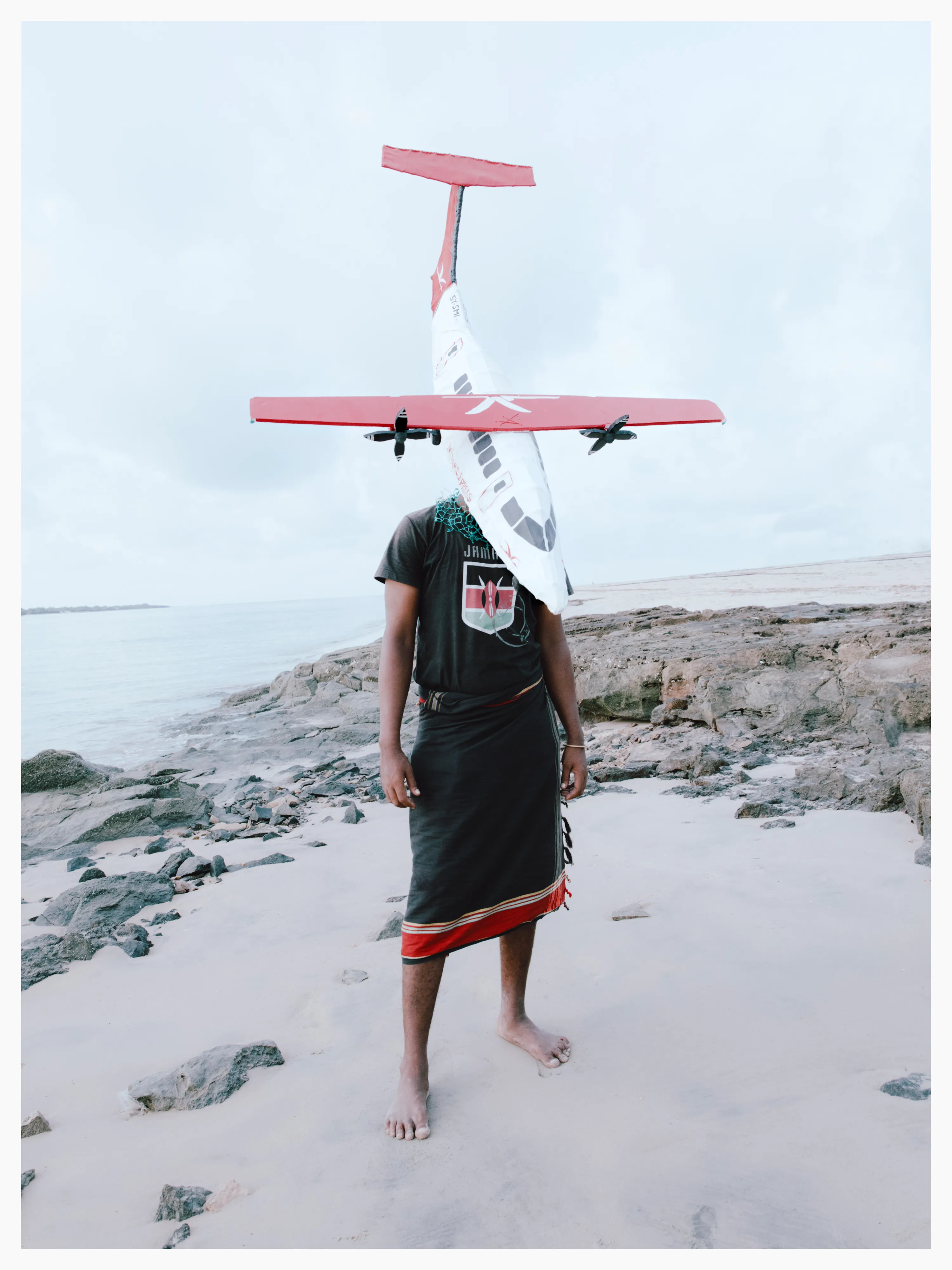 His hat, made predominantly from cardboard, is modelled on a commercial aeroplane that operates locally.

Photographed by me, styled by Louise Ford