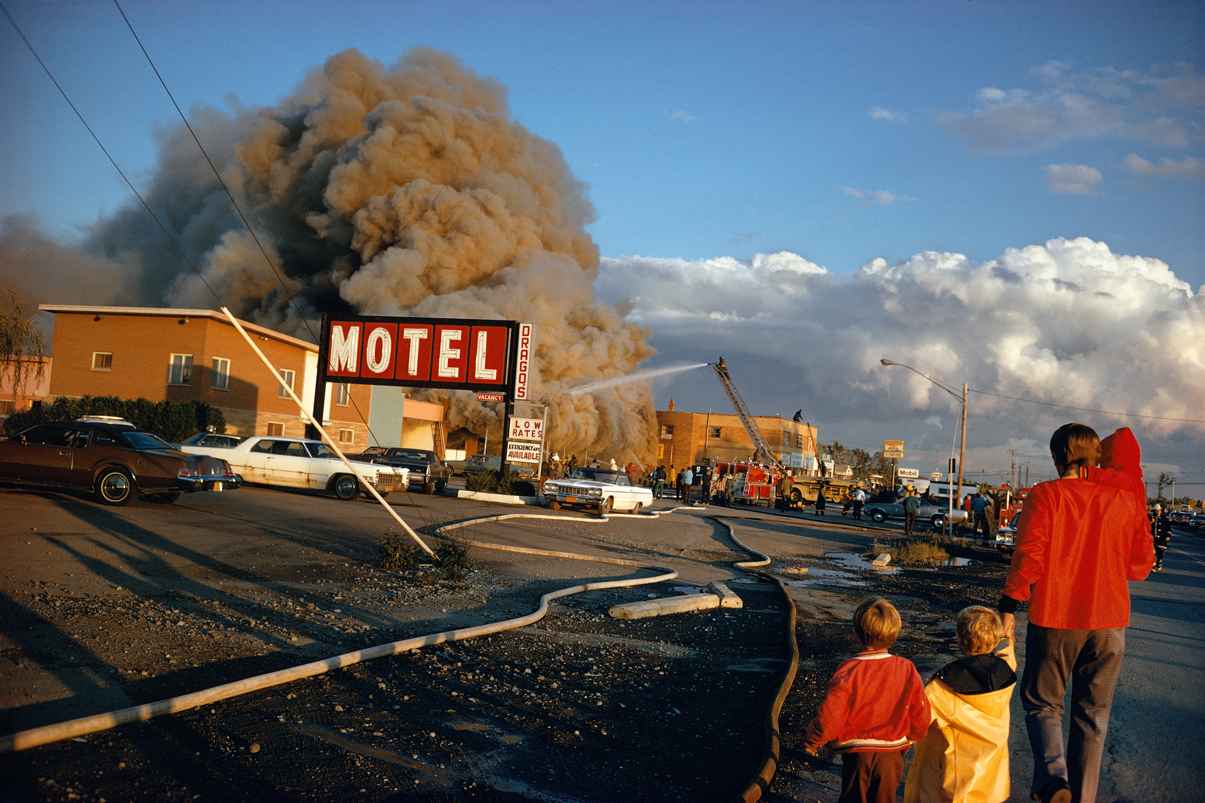 There are few ideas more central to American mythos, and to the traditions of American photography itself, than the great American road trip. Throughout his 50-year career, the photographer Mitch Epstein has ventured throughout the country seeking the nexus points that define American identity in all its strange and unexpected contradictions.

Photographed throughout the 70s and 80s, Epstein’s Recreation surveys the rituals of pleasure and undercurrent of alienation that defined late twentieth-century America. The breadth of places and subjects Epstein explored take the form of a visual epic that spans from coast to coast and across social and cultural divides. Throughout the series, the photographer’s voice intersperses joy with curiosity, sorrow with earnestness, and casts stylistic and emotional nets widely to capture the endless span of late century American identity. Epstein began Recreation at a time when color photography had barely begun to become accepted within the historical photographic canon. Along with his contemporaries in Stephen Shore, Joel Sternfeld, Joel Meyerowitz, and William Eggleston, Epstein helped to define a new photo-literative tradition while engaging in the impossible task of defining what it means to be American.

The title Recreation itself is a testament to Post-War American affluence that saturates the frames of Epstein’s pictures. When touring the work we encounter moments of mundane serenity, but also the debaucheries of nightlife, antics of American youth, and the enriched banalities of family life. What we see in Epstein’s pictures are time capsules of a particular era of American capitalist excess, a cultural snapshot of the last vestiges of pre-techno-dominant lifestyles, and an ode to the attitudes of American exceptionalism that proudly pronounce, “we just do what we want.”

Edition: 1 of 1