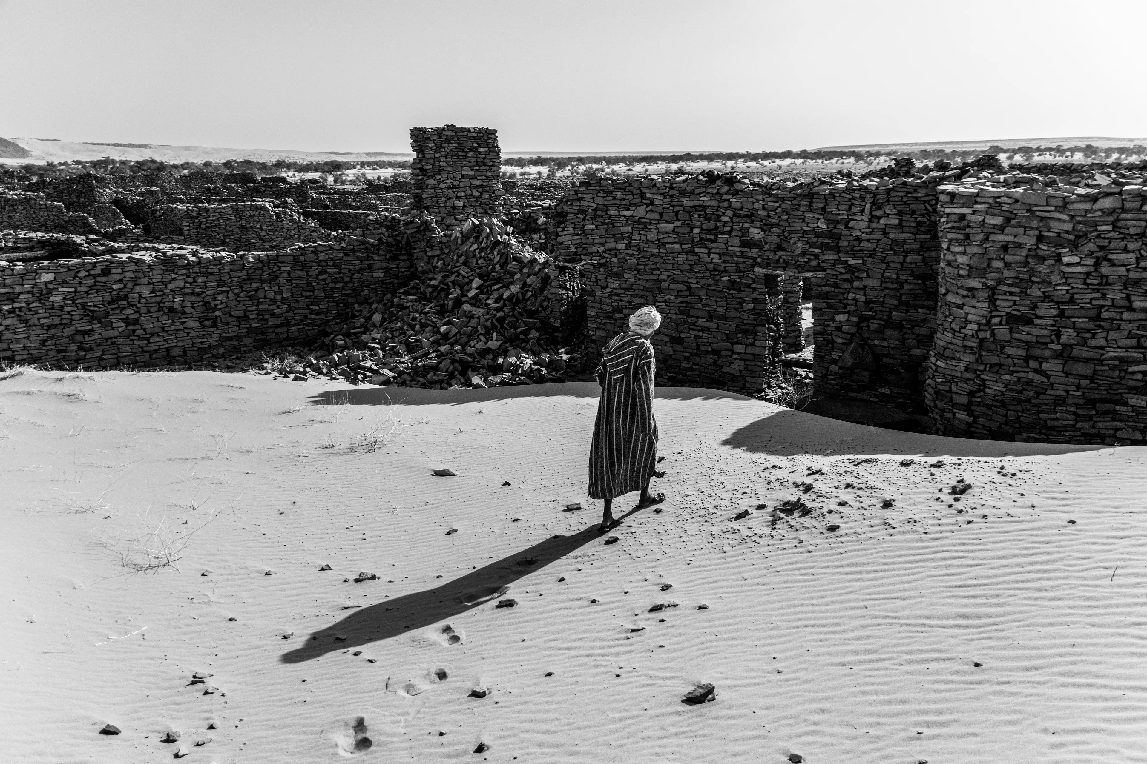 Navigating us around the walls of Ksar el Barka, Abdallahi embodied the spirit and memory of this ancient fortified village. In the sand, his shadow stretches far larger than his figure, a quiet reminder that his legacy, like the stories of those who built and protected these walls, looms larger than any one person. His presence is a living link to the past, preserving history for generations to come.