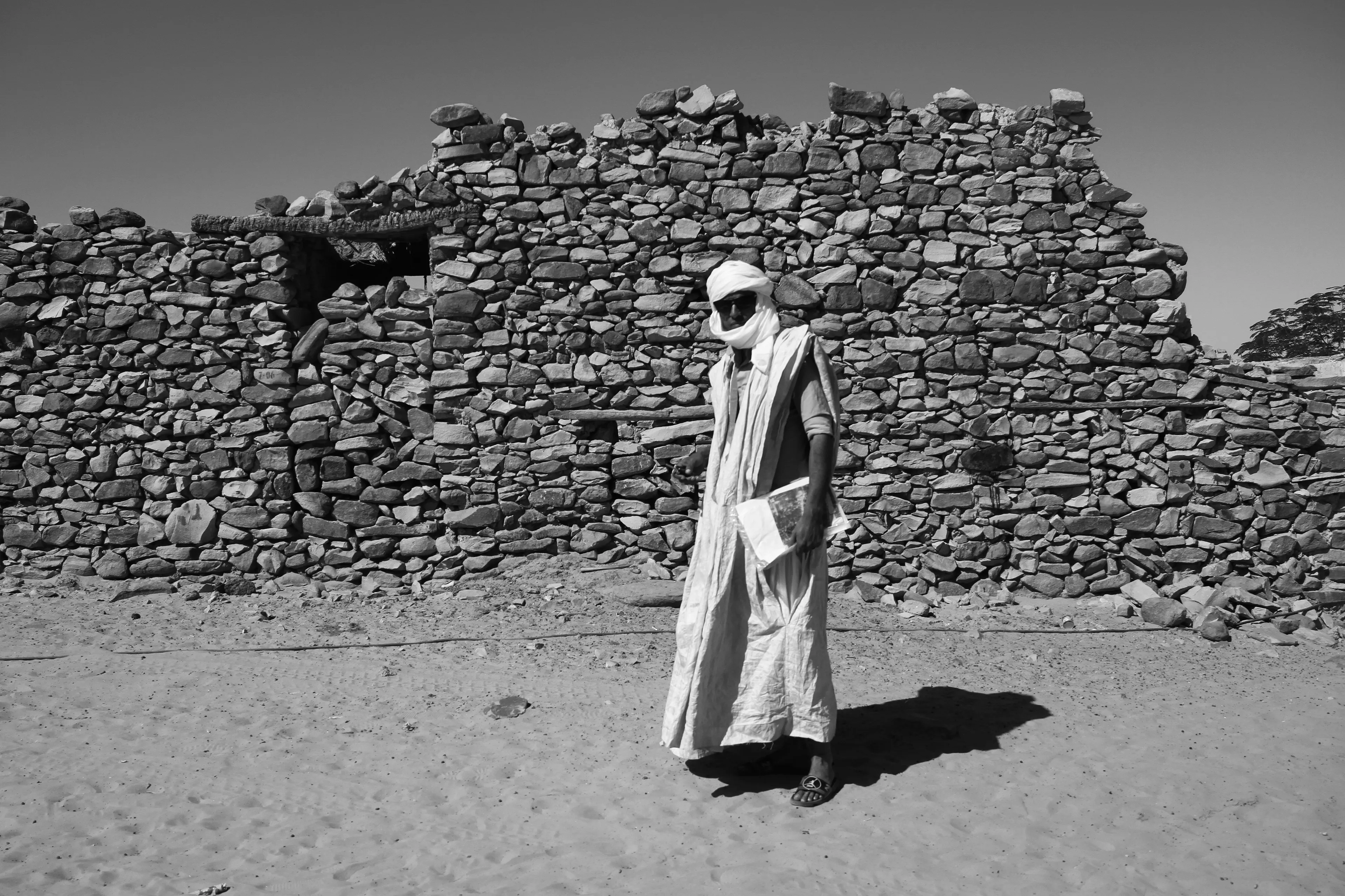 Learning from the spirit of Chinguetti, Chikali carries books and documents like a devoted student, embodying the desert’s ancient legacy of scholarship.