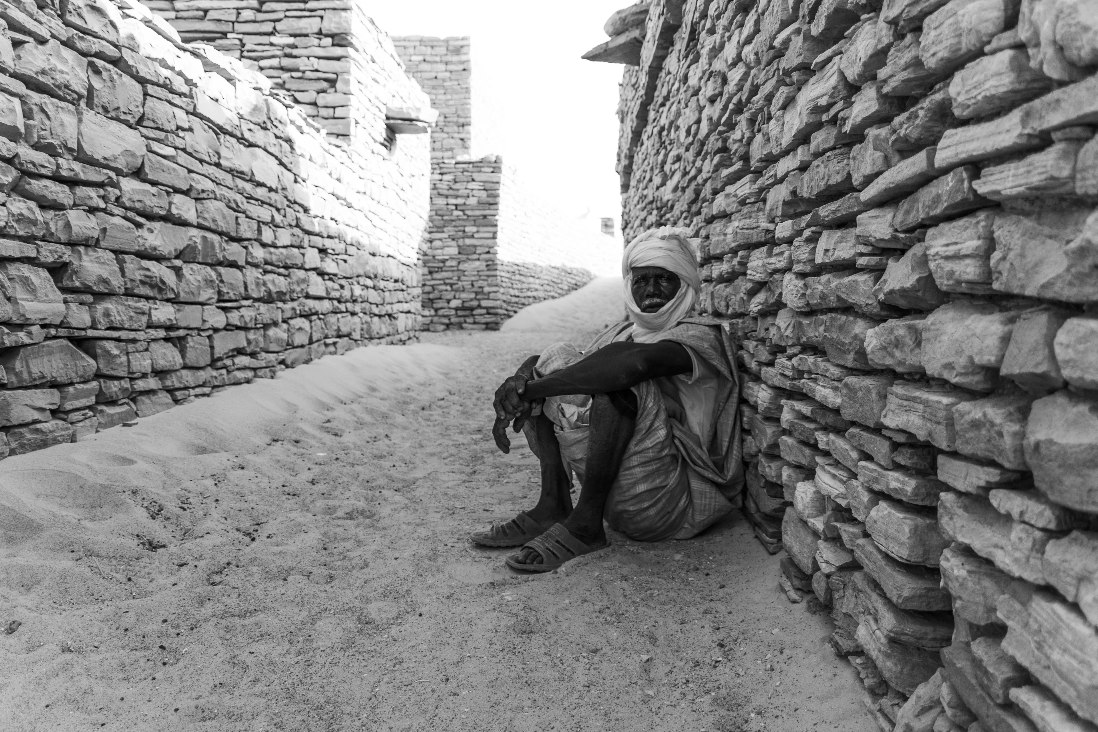 He suddenly appeared out of nowhere. We were drawn to the main courtyard and the mosque, so perfectly preserved and clean they seemed newly built. The man approached us, he was the guardian, and shared how, in Tichit, many of the buildings had been reconstructed using the exact techniques of the city’s original builders. We stood under the scorching sun, and as he unfolded the history of this enchanting place, we slipped into the shade behind a wall, where the temperature dropped just a few degrees. I still remember the gentle breeze that drifted through that quiet alley.